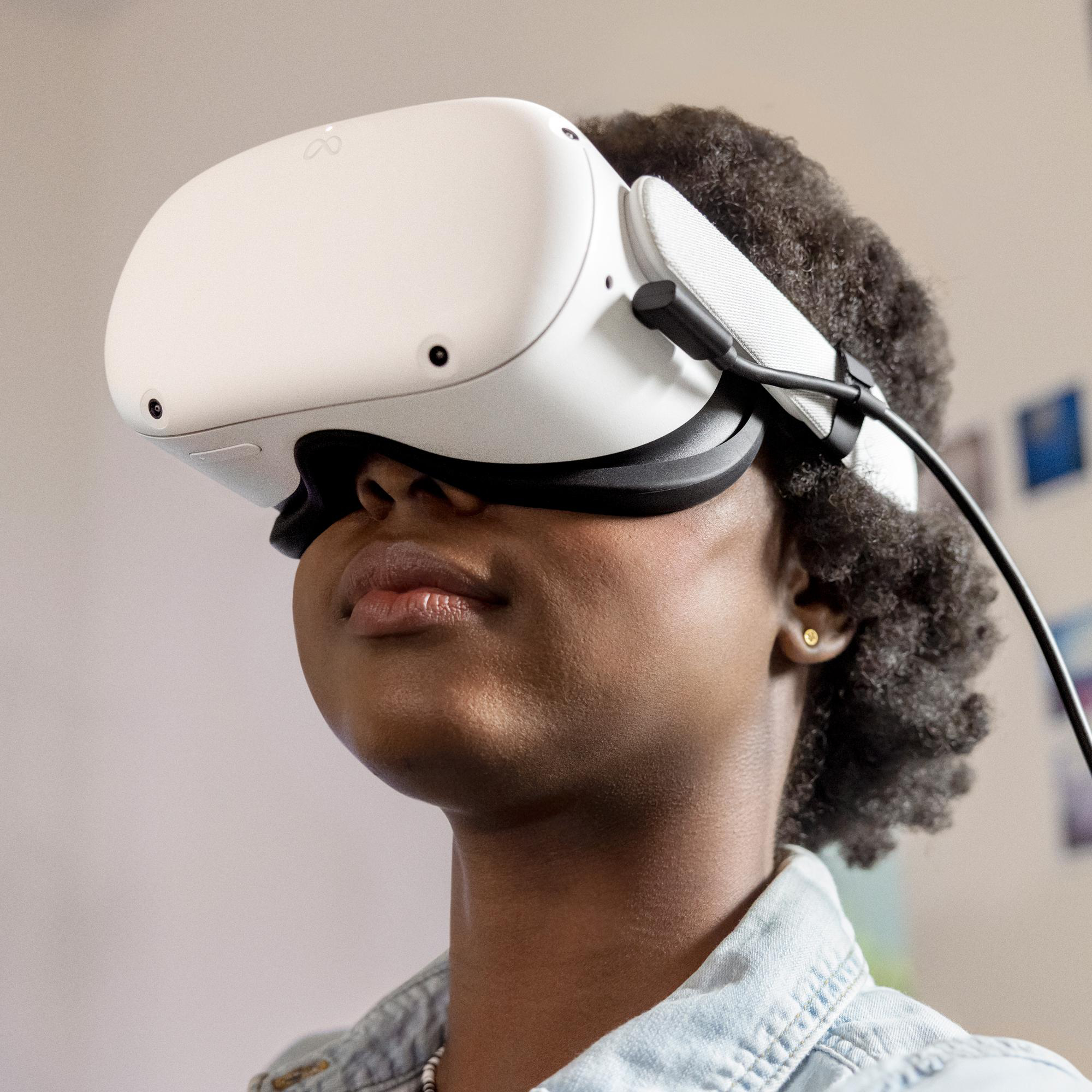 Frau mit VR-Headset, trägt Jeanshemd, schaut nach oben.