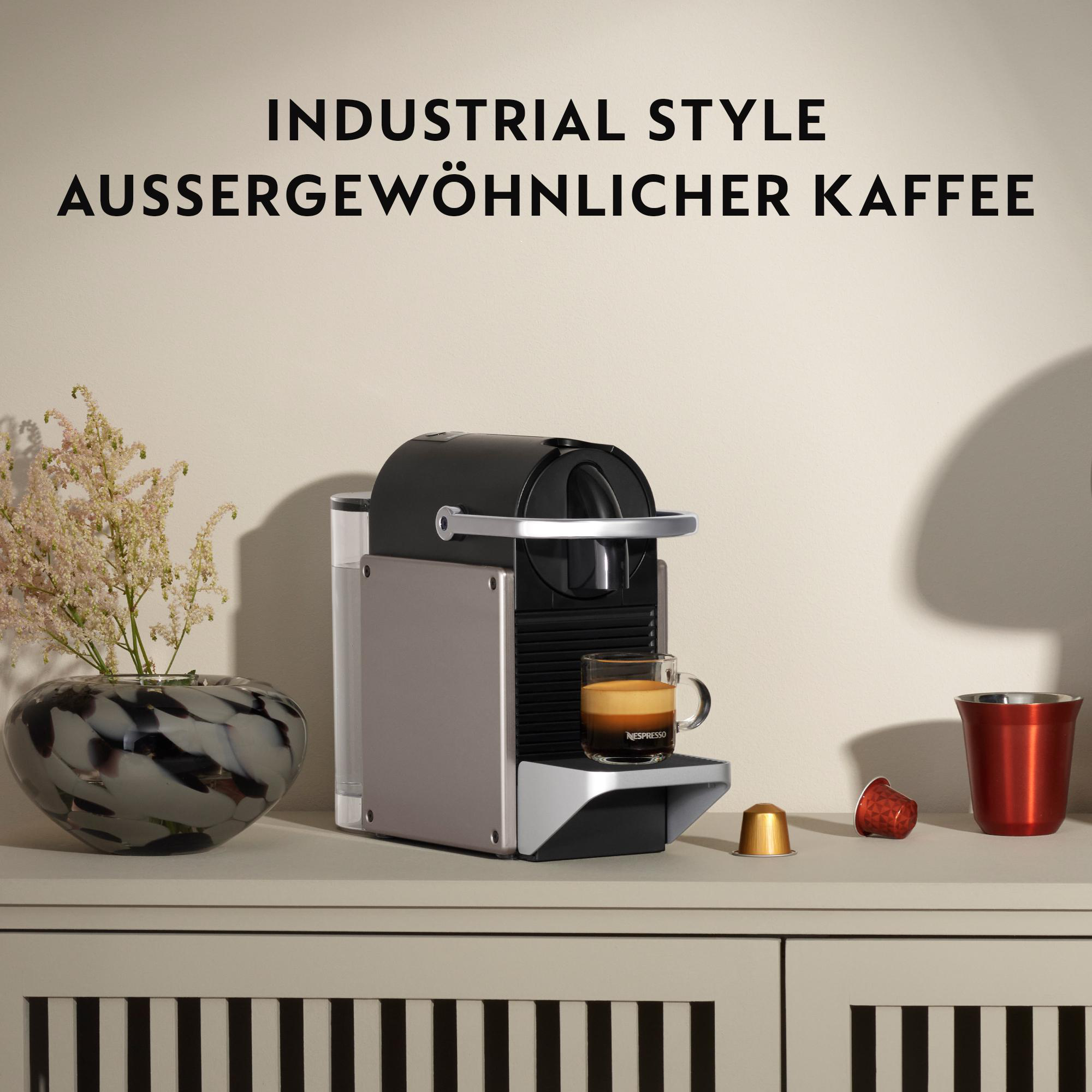 Eine Nespresso-Maschine mit schwarzem und silbernem Design, mit einer Kaffeetasse.