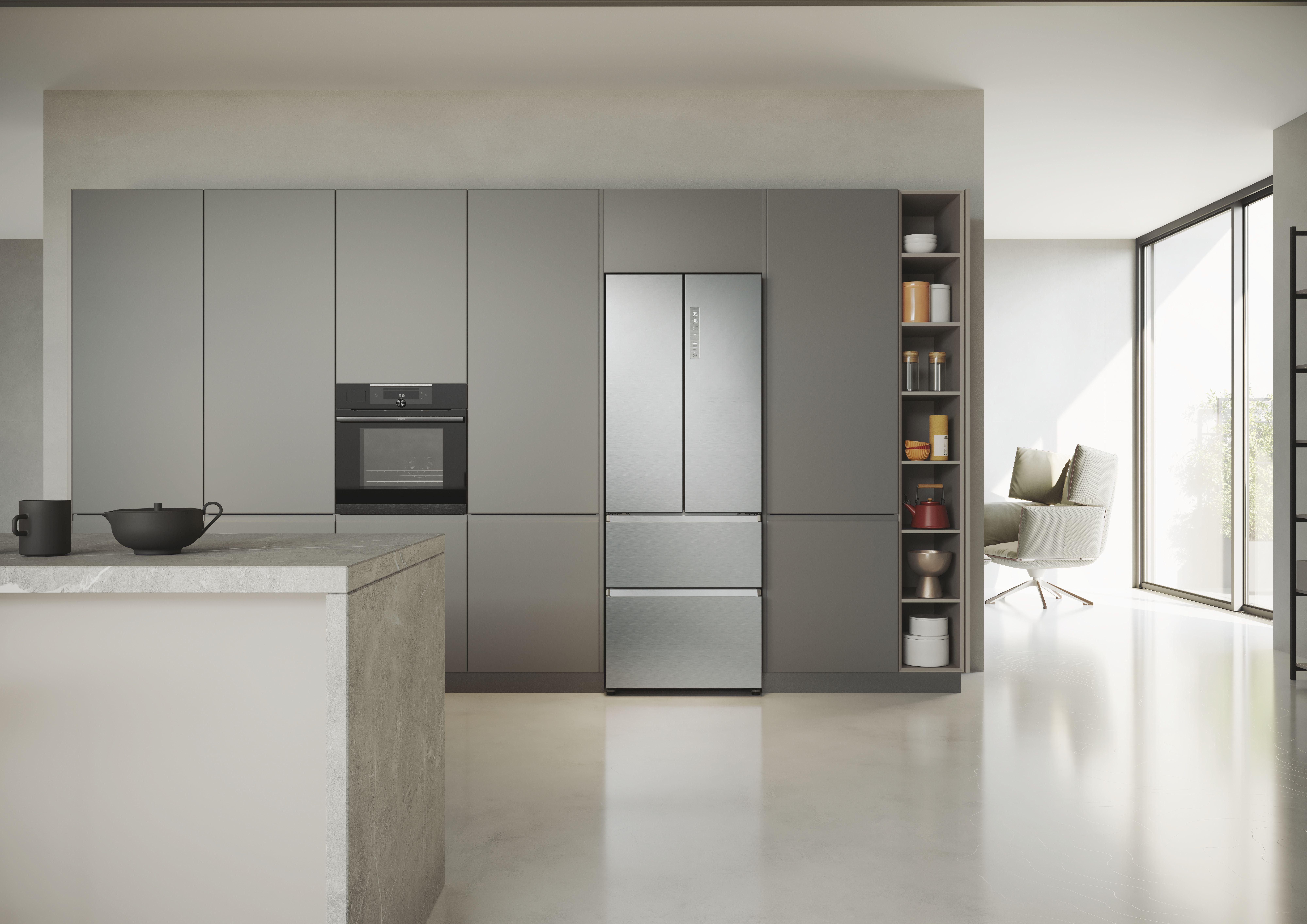 Moderne graue Küche mit Edelstahlkühlschrank und Backofen. Weiße Arbeitsplatte und ein Stuhl.