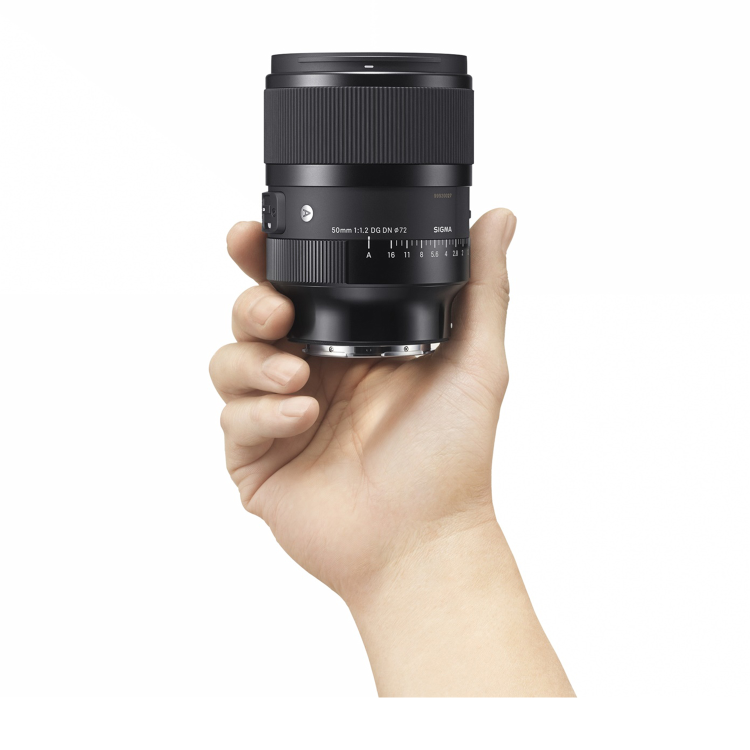 Una mano che tiene un obiettivo nero per fotocamera su sfondo bianco.