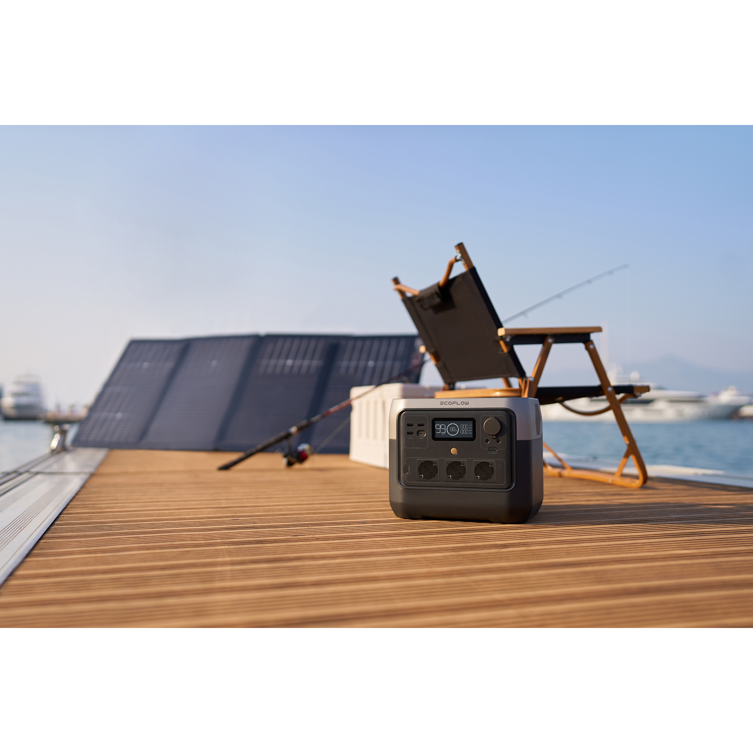 Centrale électrique sur un quai, matériel de pêche et panneaux solaires en arrière-plan. Jour ensoleillé.