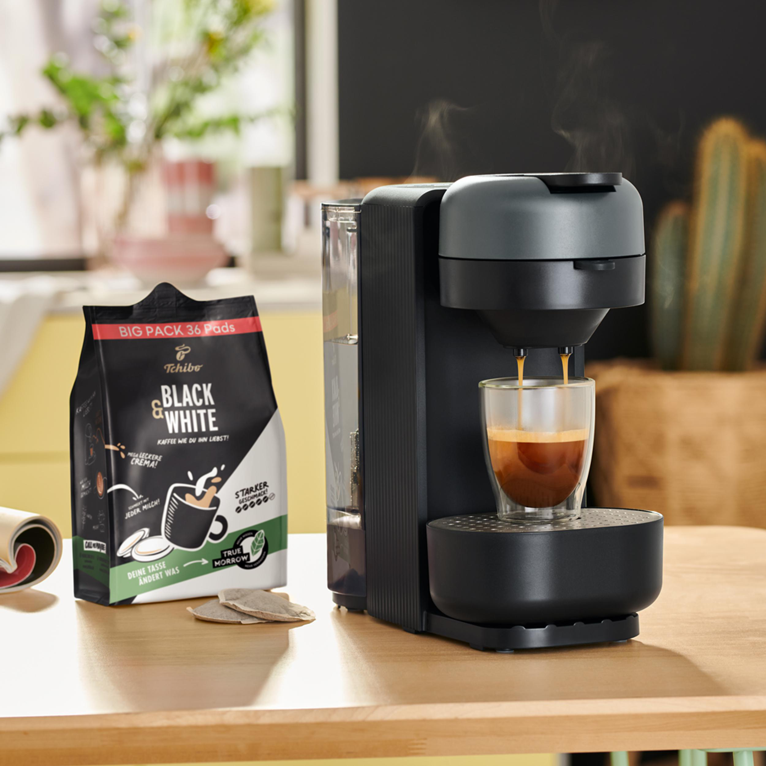 Kaffeemaschine, die Espresso zubereitet. Daneben eine Tüte Kaffeepads.