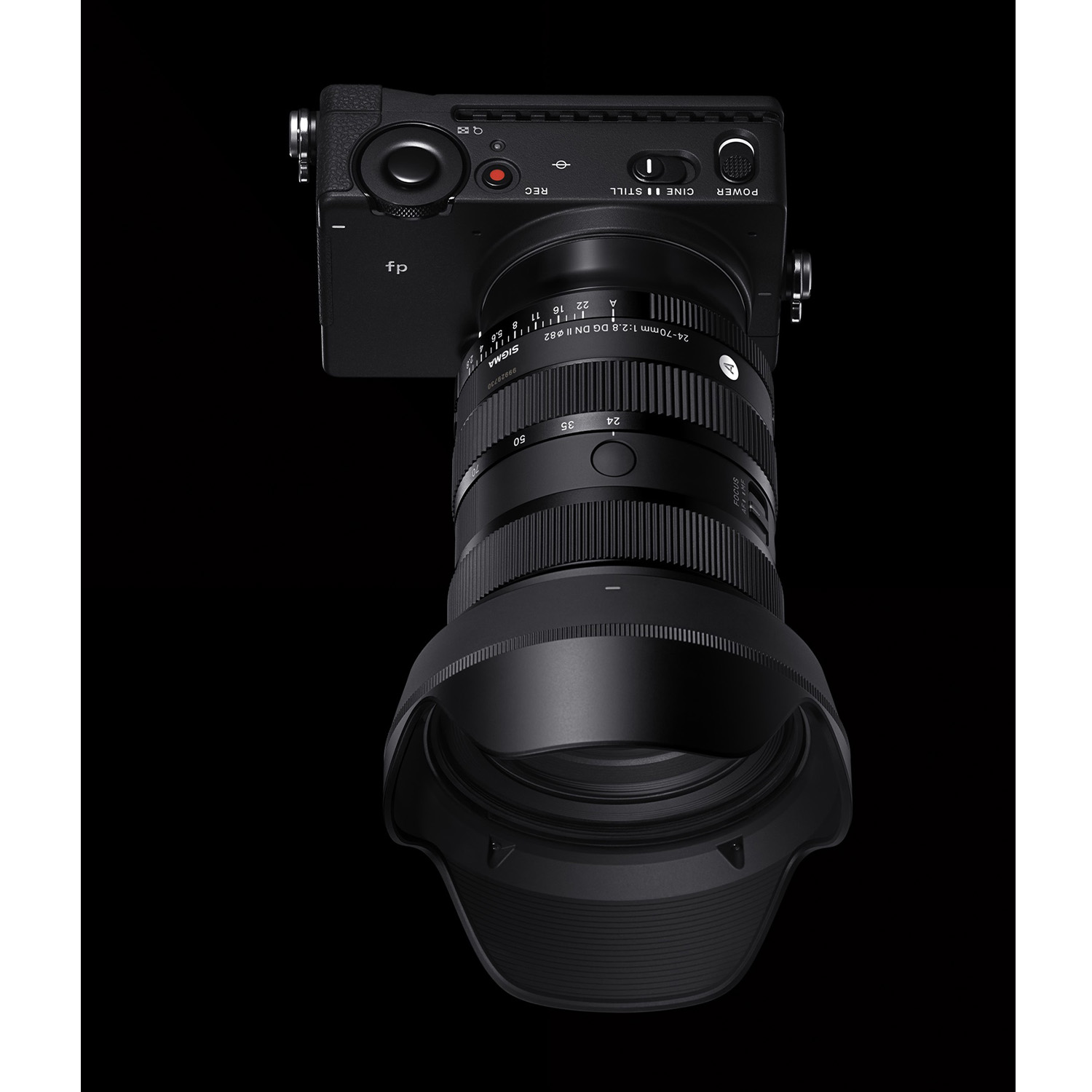 Una fotocamera nera con un obiettivo. La fotocamera è su una superficie nera.