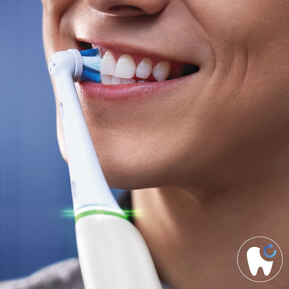 Personne se brossant les dents avec une brosse à dents électrique, dents blanches.