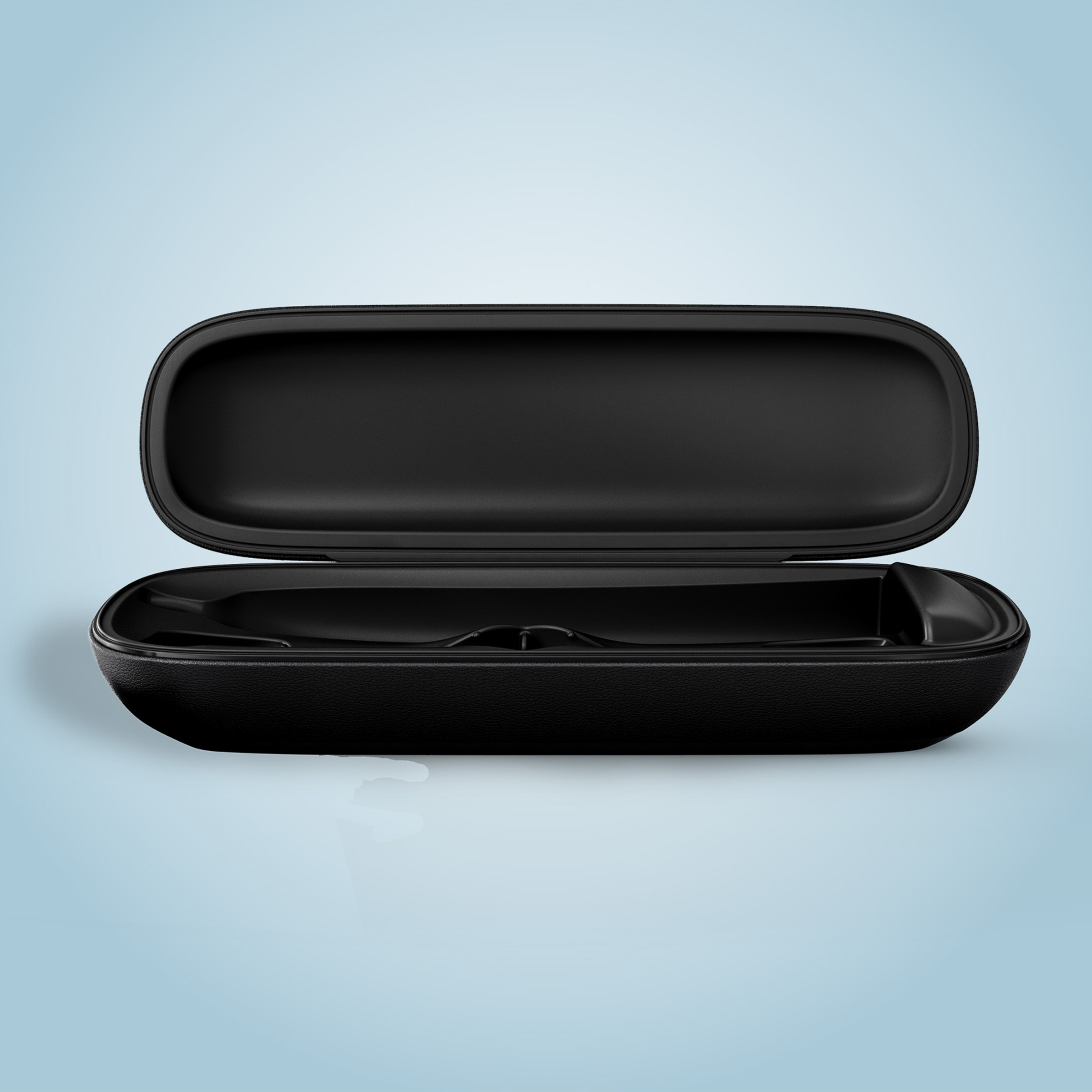 Otwarty czarny futerał na okulary na jasnoniebieskiej powierzchni.