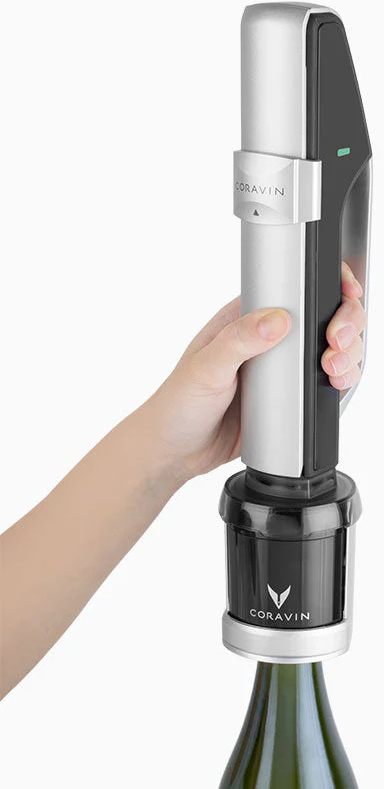 Eine Hand, die einen Coravin-Weinöffner auf einer Weinflasche hält.