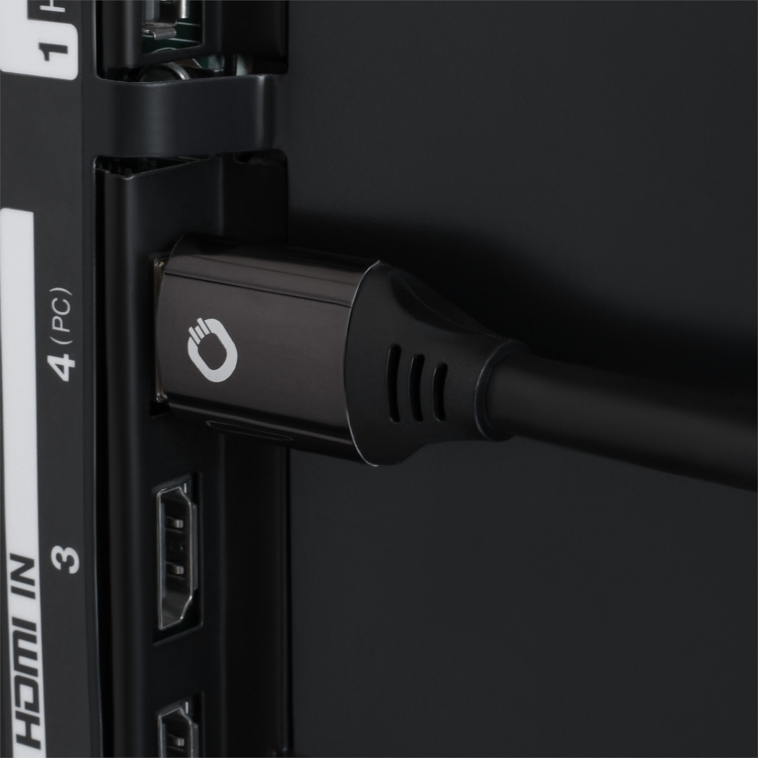 Gros plan d'un câble HDMI noir branché sur un téléviseur. Montre le câble et le port HDMI du téléviseur.