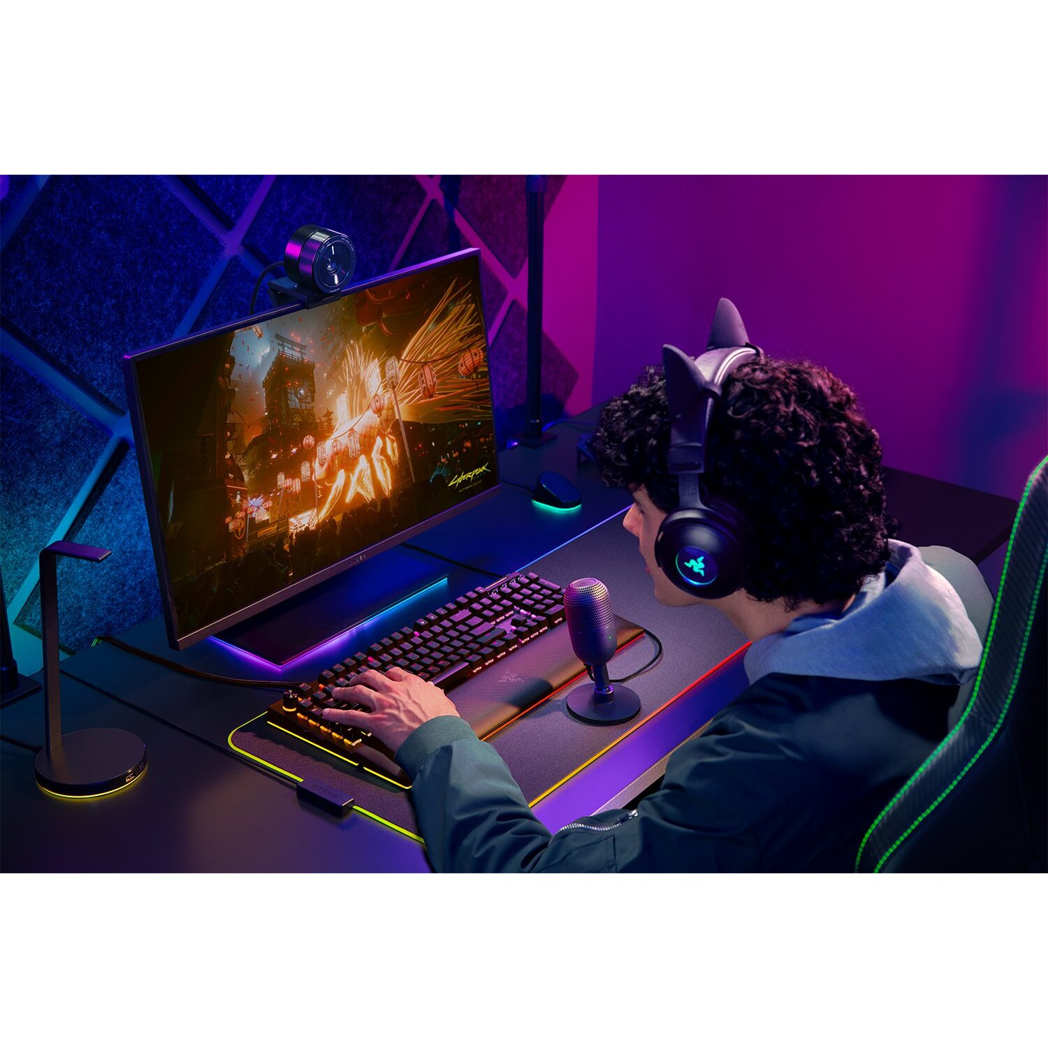 Un homme jouant avec un moniteur, un clavier et un casque.
