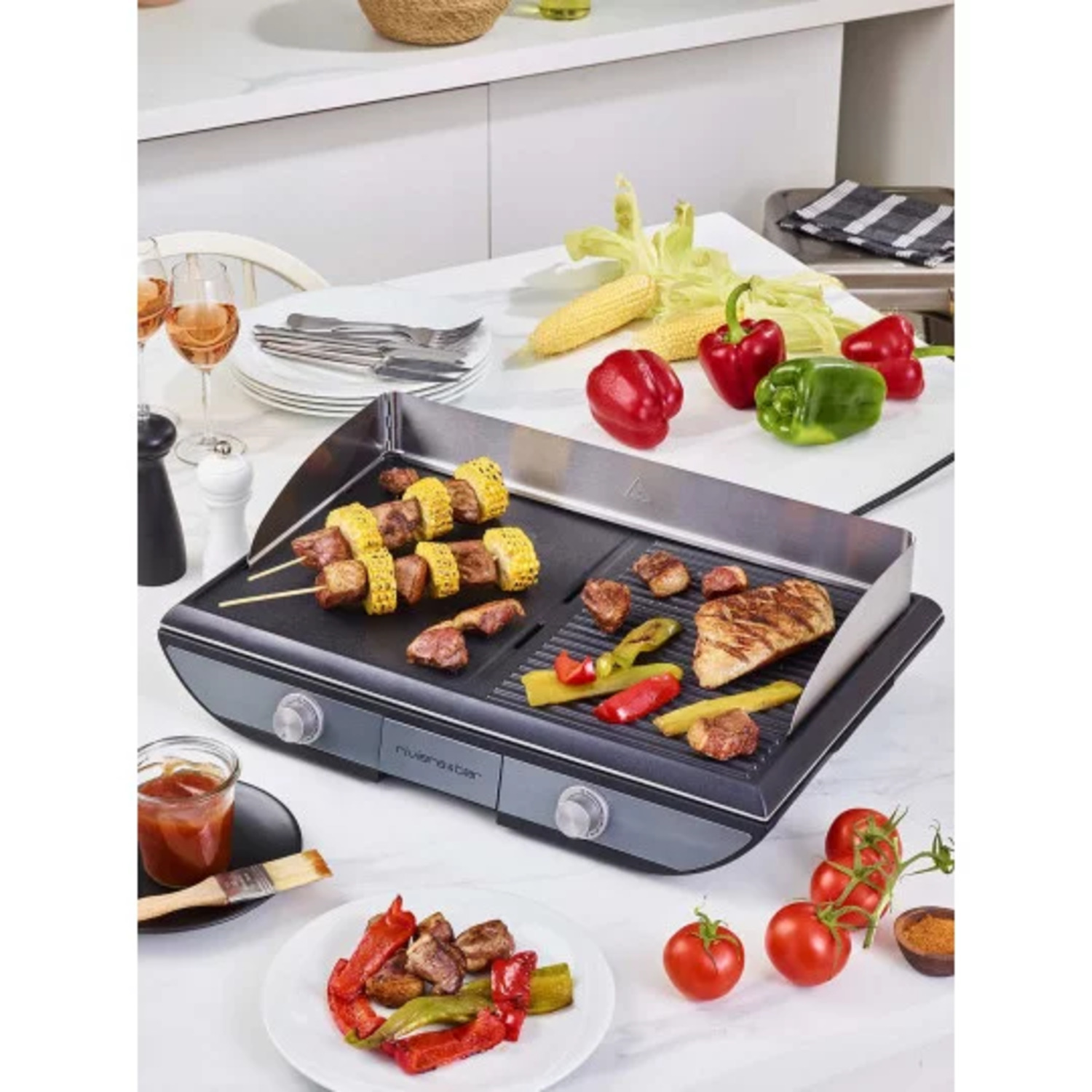 Gril avec de la nourriture, dont des brochettes, des légumes et de la viande. Poivrons rouges, tomates et épis de maïs.