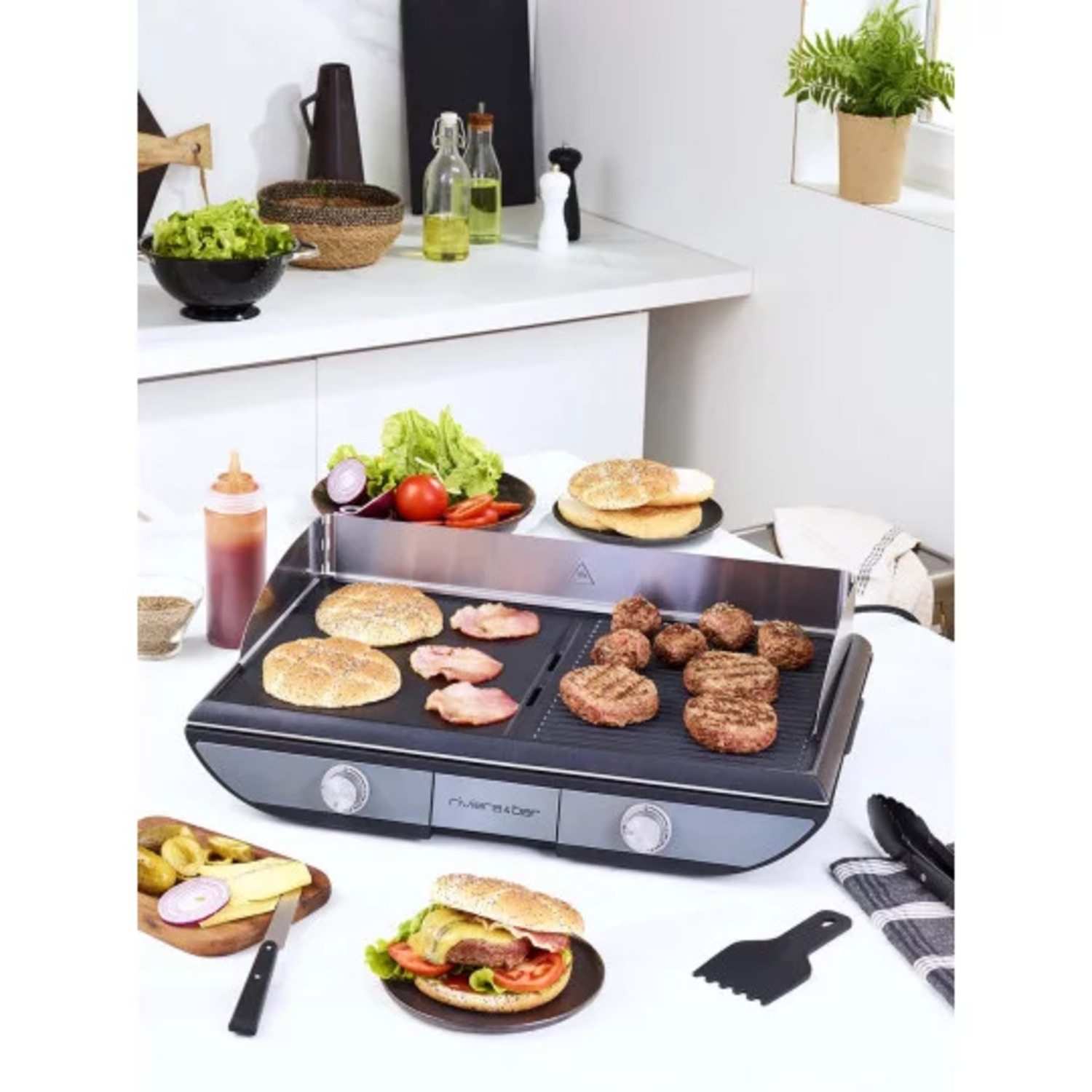 Grill avec burgers et pains, salade et condiments sur un comptoir blanc.