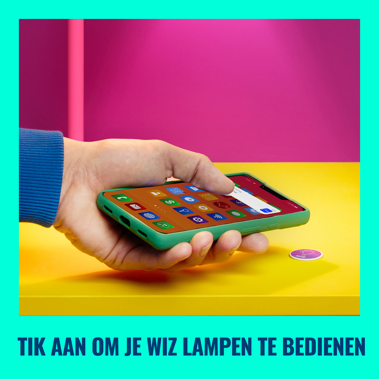 Een hand die een telefoon vasthoudt met app-pictogrammen, op een gele tafel, met een sticker.
