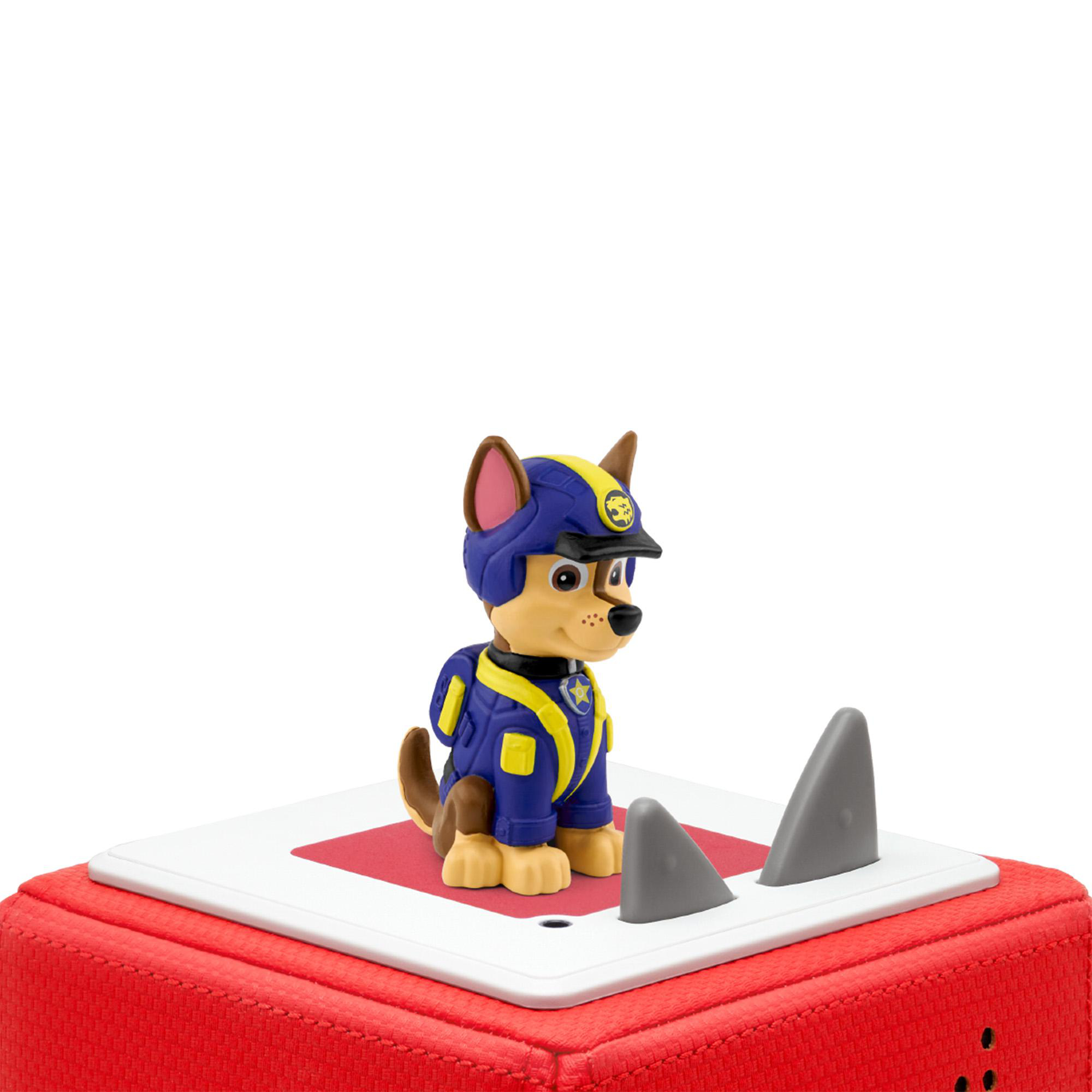 Chase, ein Spielzeughund von Paw Patrol. Er steht auf einer roten Oberfläche.