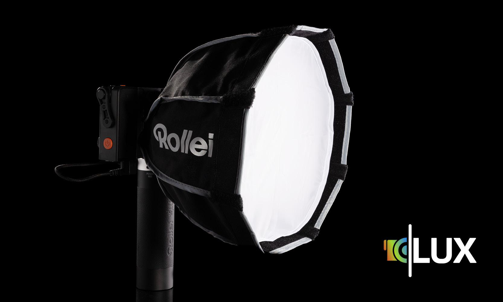 Ein Studiolicht mit einer schwarzen, achteckigen Softbox und einem Logo. Der Hintergrund ist dunkel.