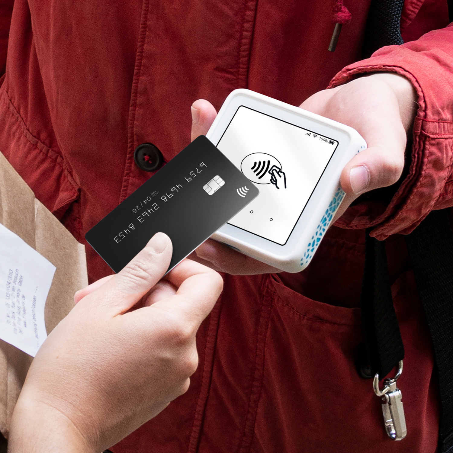 Persoon betaalt met een zwarte creditcard via een contactloos betaalapparaat.