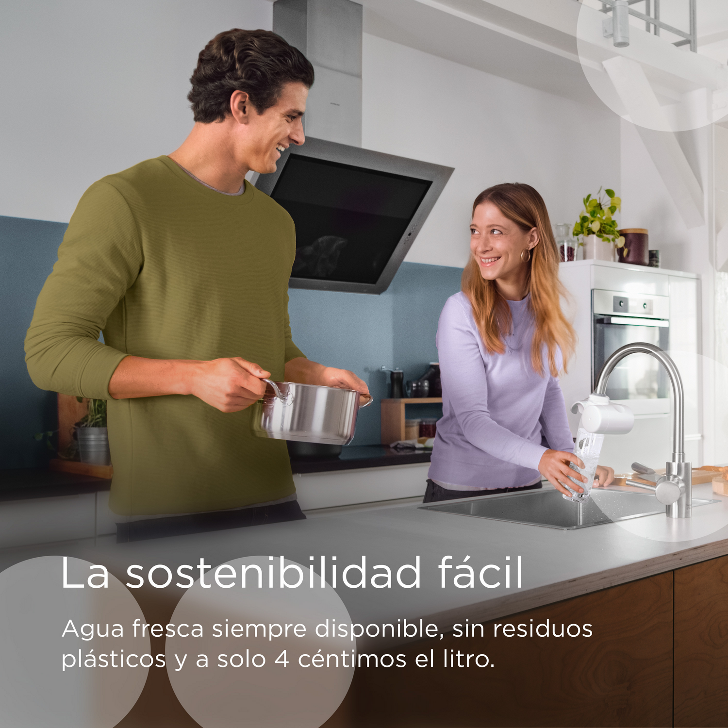 Una pareja en una cocina cerca de un fregadero y sistema de filtración de agua, sonriendo e interactuando.