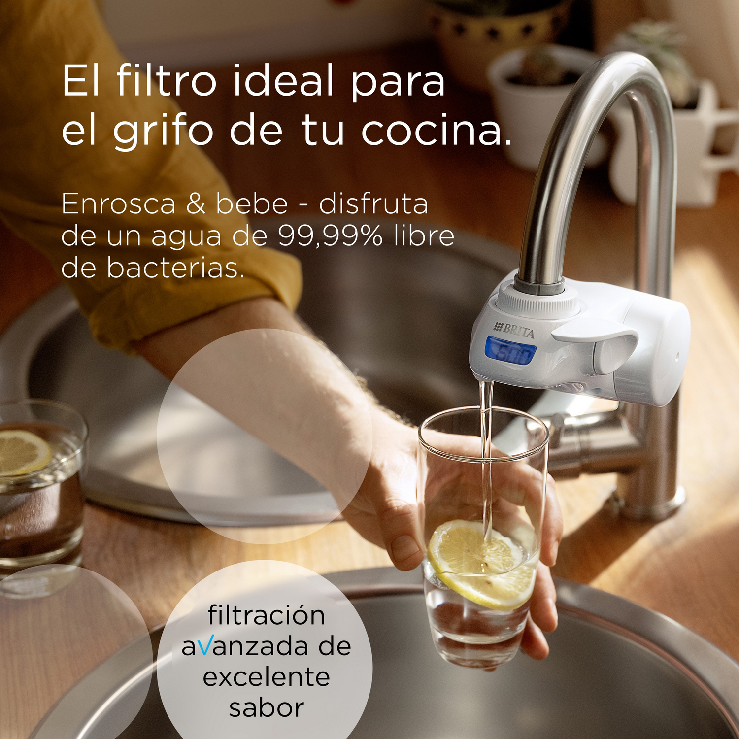 Una persona llena un vaso con agua de un grifo con un filtro adjunto.