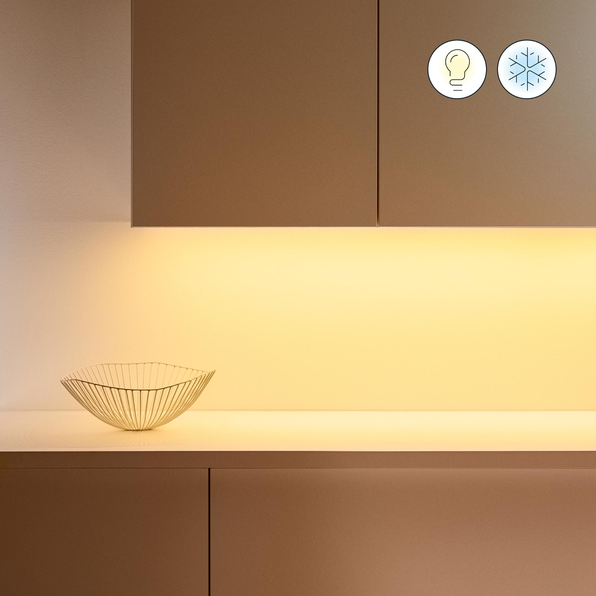 Küche mit Arbeitsplatte und Schüssel, beleuchtet von einem Lichtband.