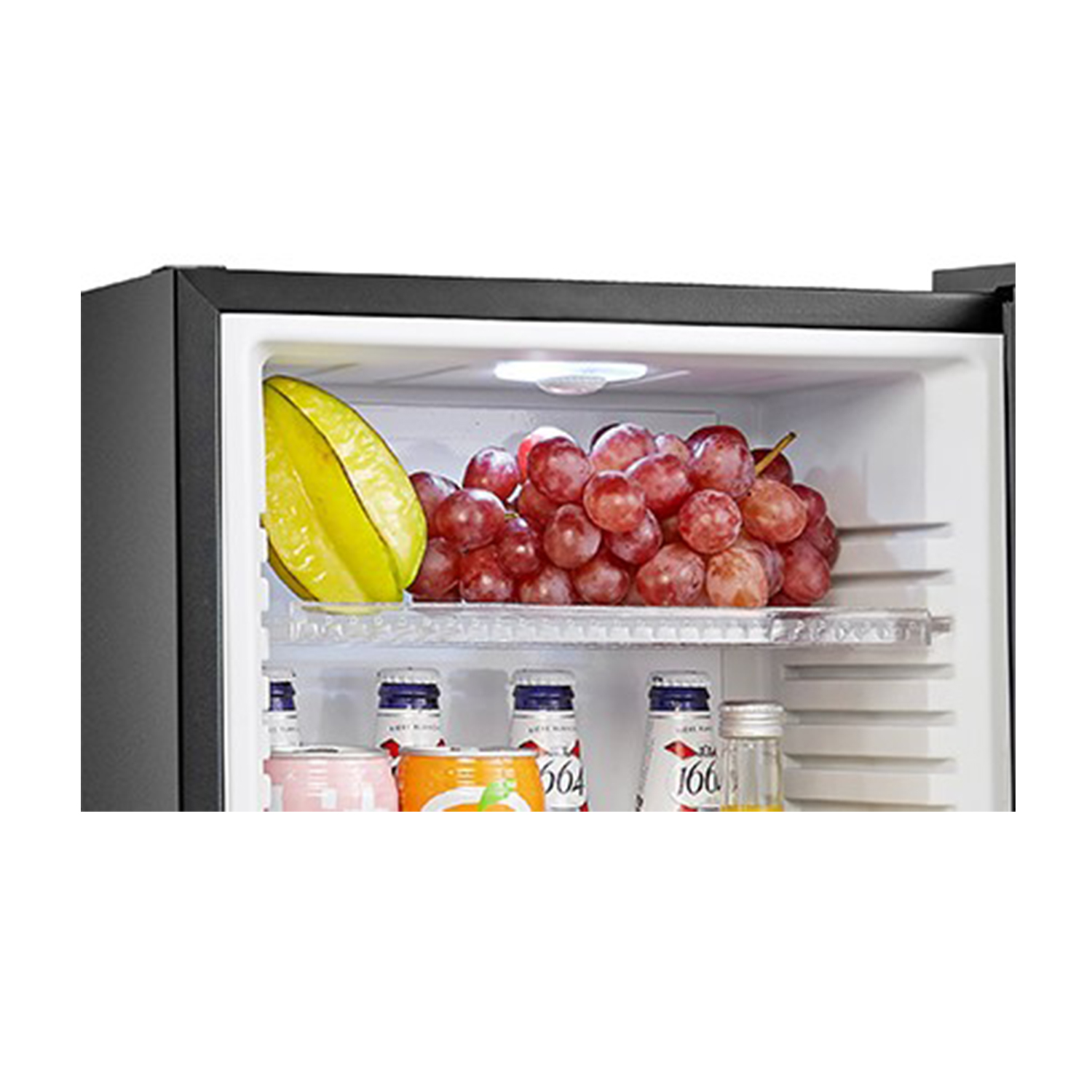 Un interno di mini-frigo con uva, carambola e bottiglie.