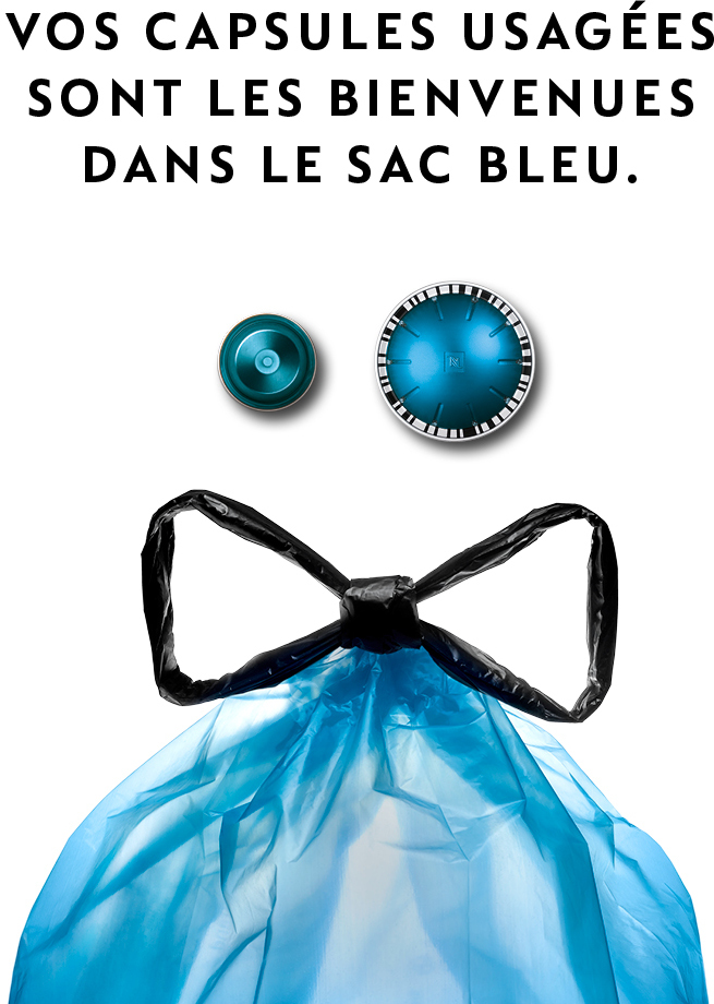 Sac poubelle bleu avec deux capsules Nespresso usagées sur fond blanc.
