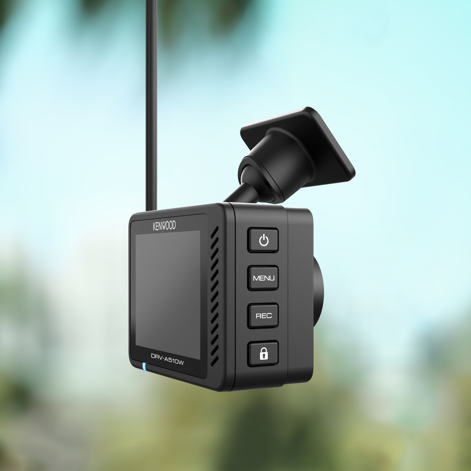 Black Kenwood dashcam with buttons and a small screen, mounted on a windshield. Blurred background.