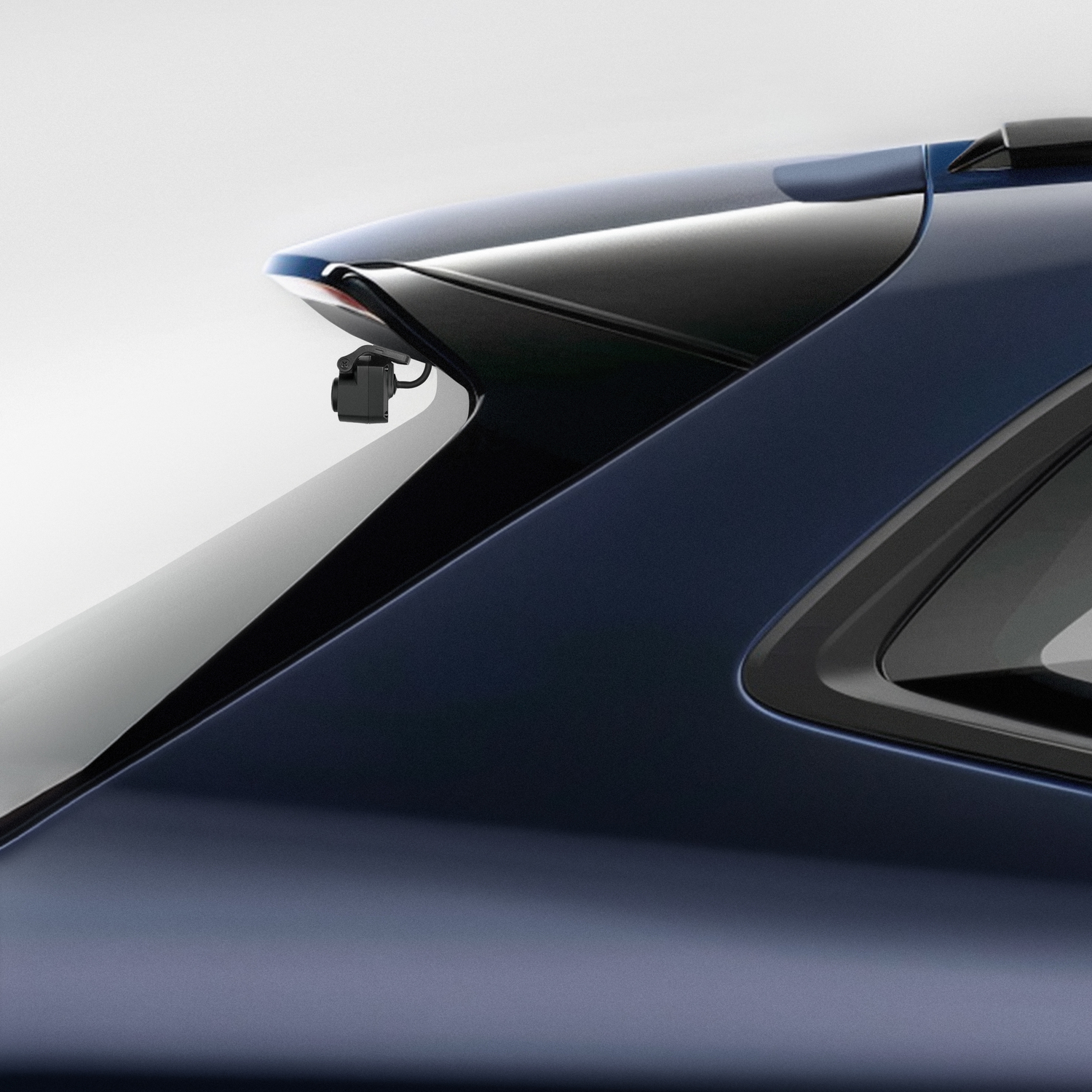 A dark blue car with a rear camera mounted on the top of the trunk.