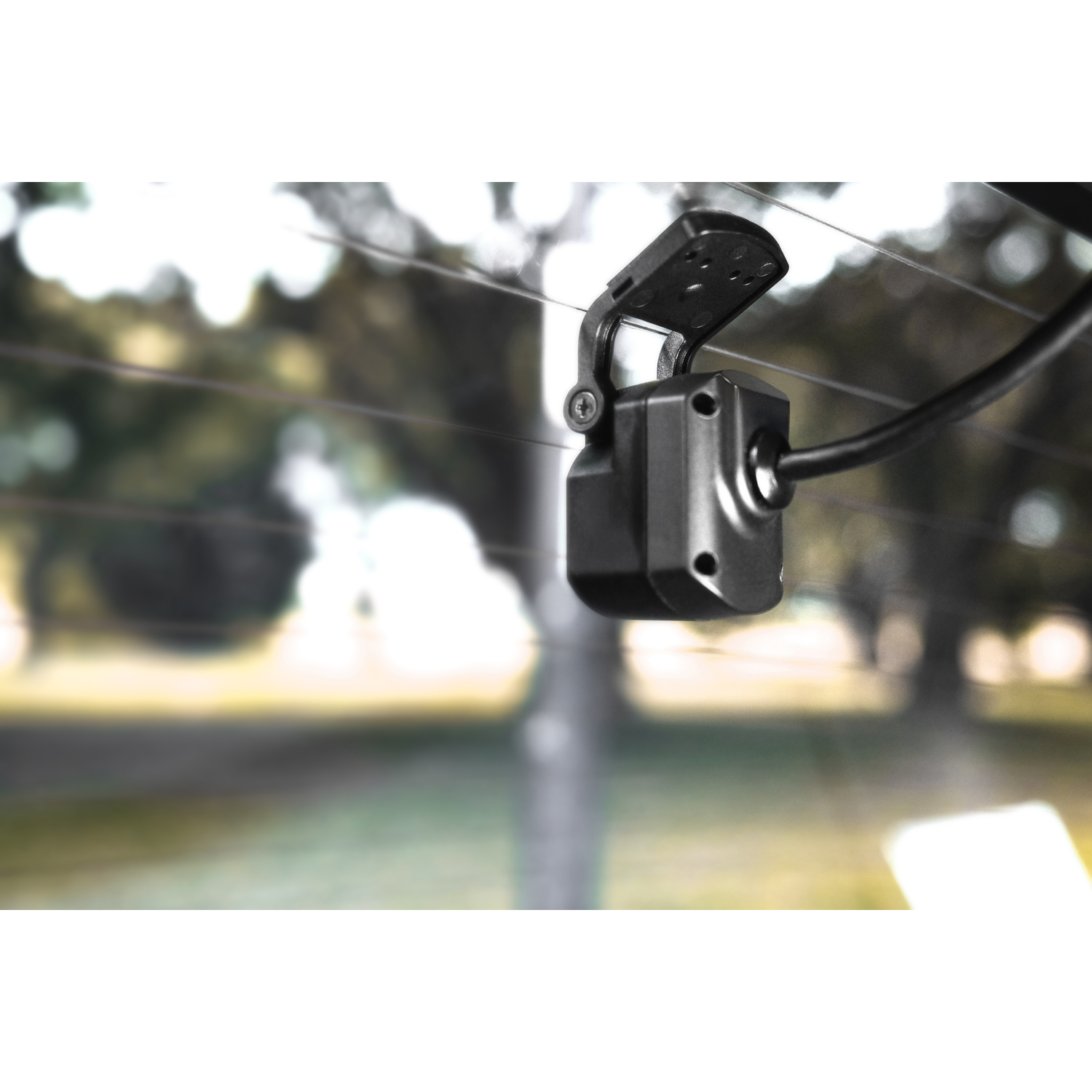 Black car camera mounted on the rear windshield, with a blurry background.