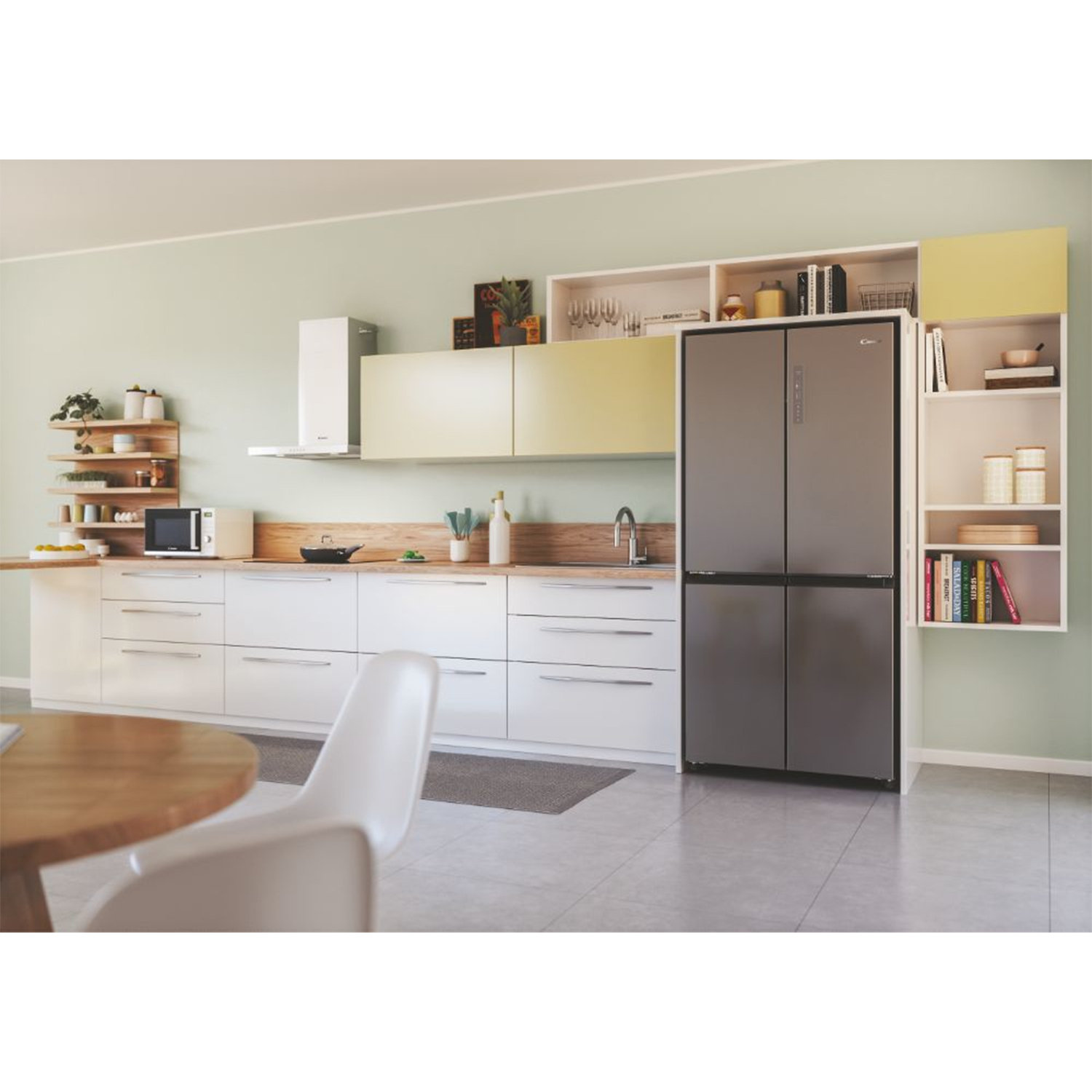 Una cucina moderna con frigorifero scuro, mobili bianchi e zona pranzo.