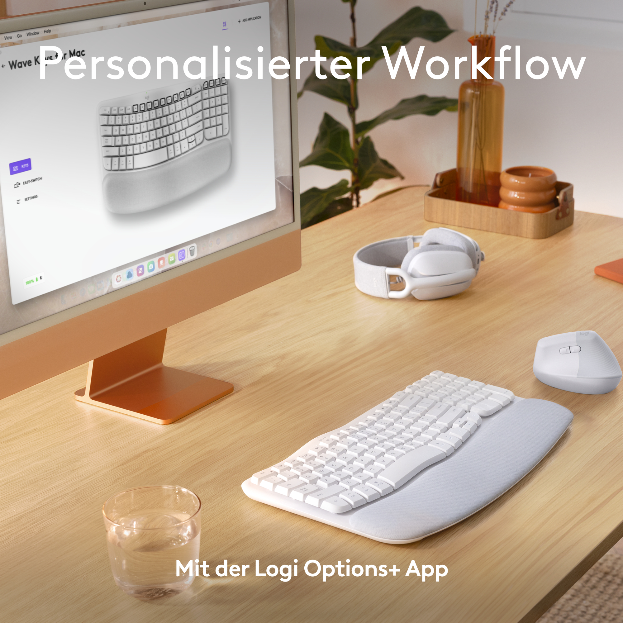Arbeitsplatz mit weißer ergonomischer Tastatur und Maus, Computermonitor und Holztablett.