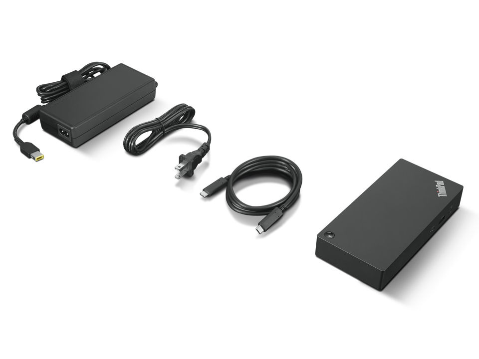 Adaptador de corriente para portátil negro, cable de carga y base sobre fondo negro.