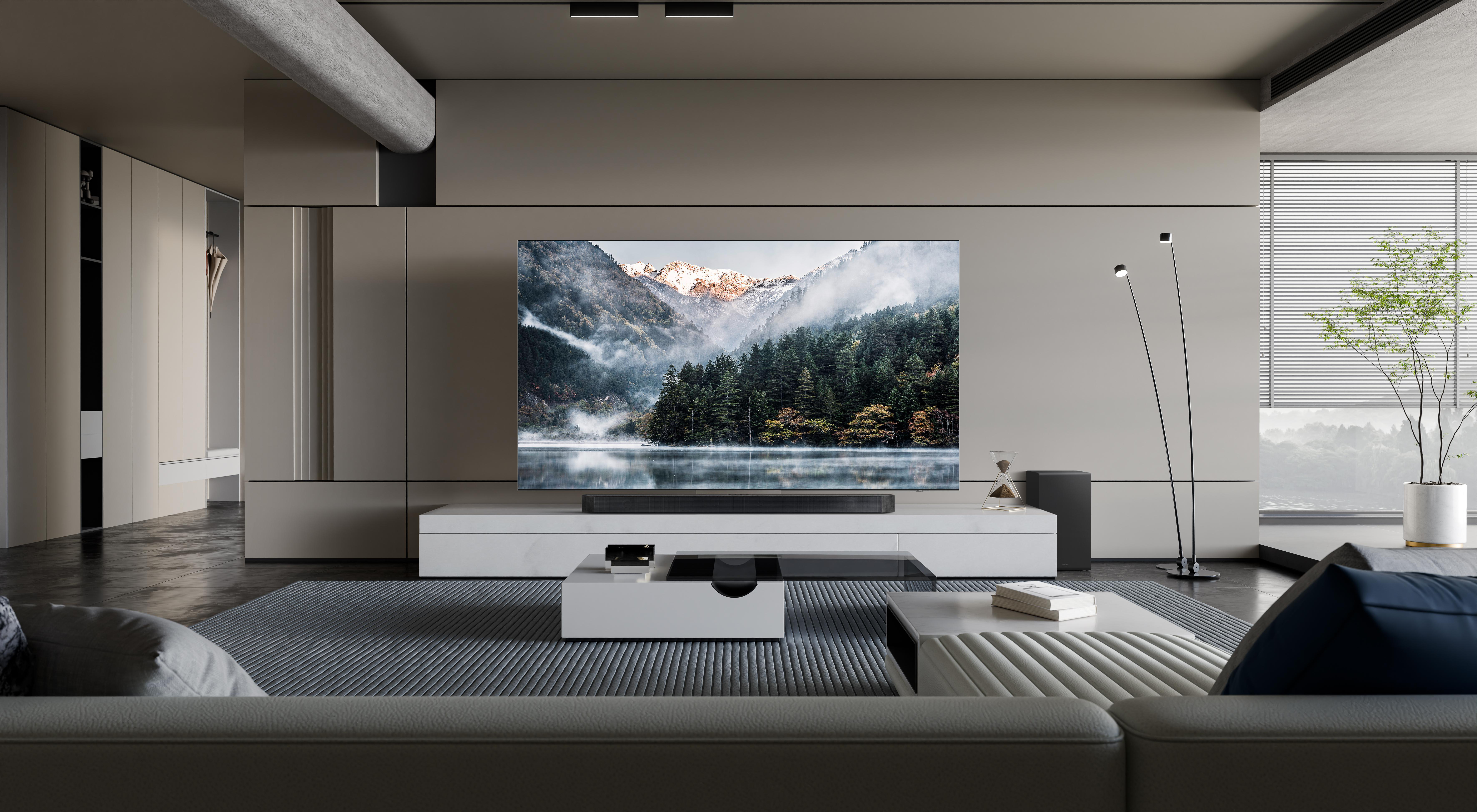 Ein modernes Wohnzimmer mit großem Fernseher, Sofa und Blick auf eine Berglandschaft.