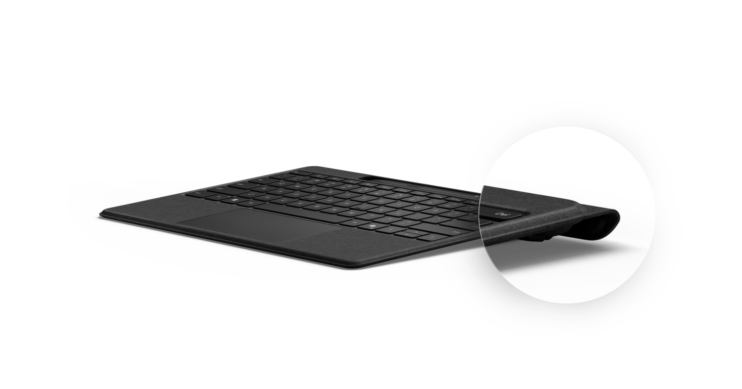 Un teclado negro con un borde curvo, visto desde un ángulo lateral.