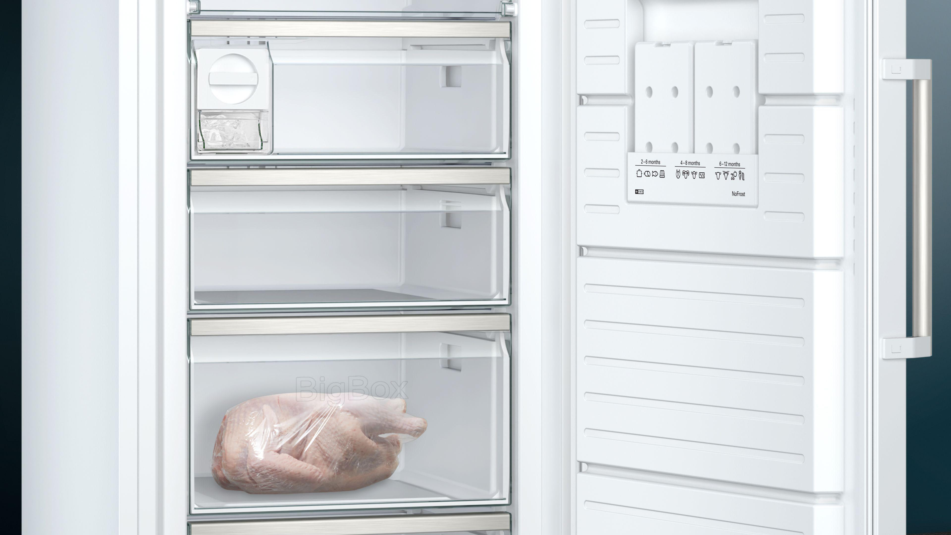 Offener weißer Gefrierschrank mit Regalen, Schubladen und einer Fleischverpackung in der unteren Schublade.