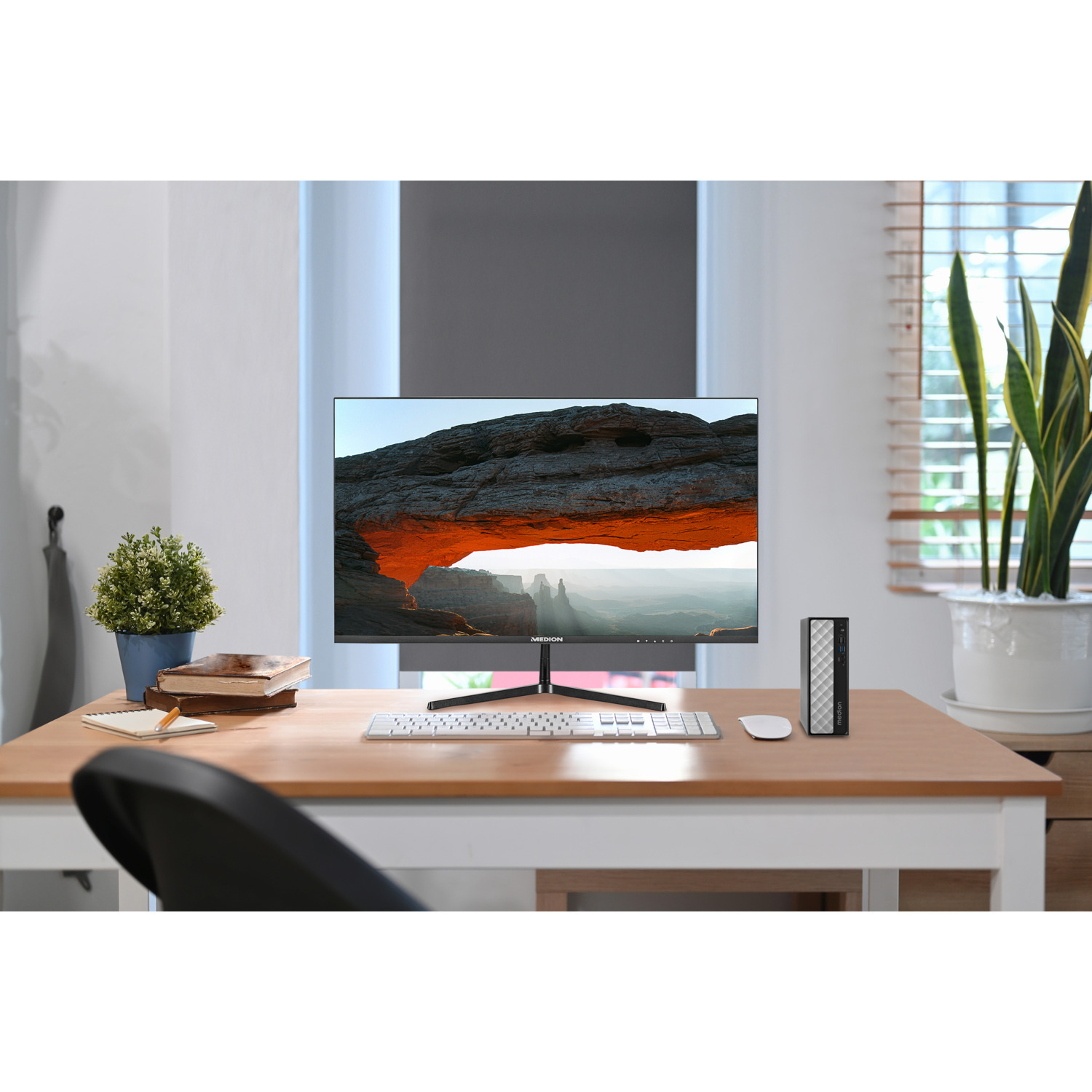 Een computermonitor, toetsenbord, muis en pc-toren staan op een houten bureau.