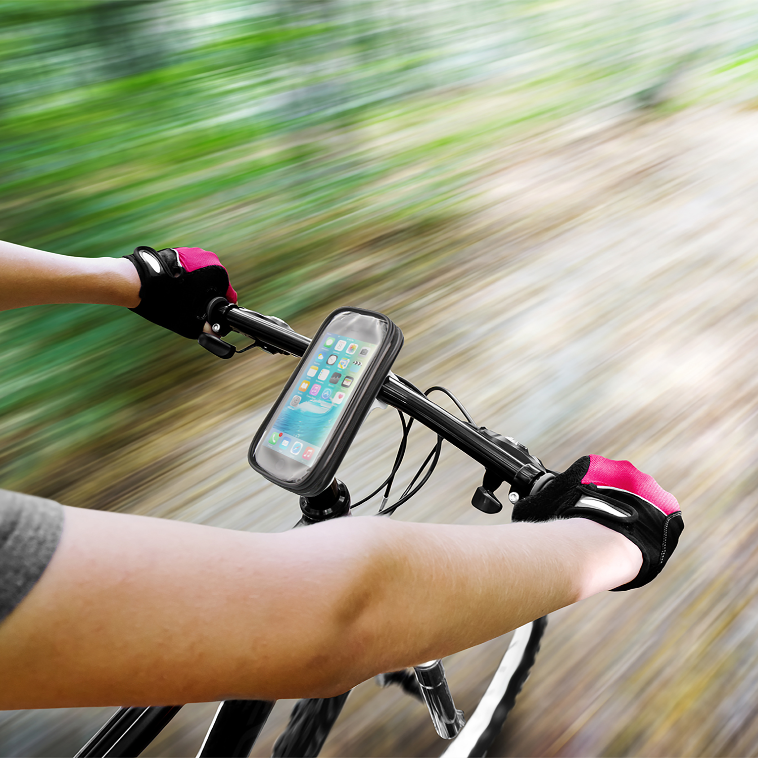 A person riding a bicycle with a phone mounted on the handlebars. The background is blurred.