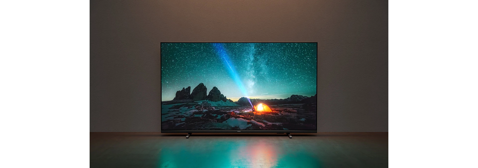 Un televisor que muestra una escena nocturna con una tienda y una luz colorida.