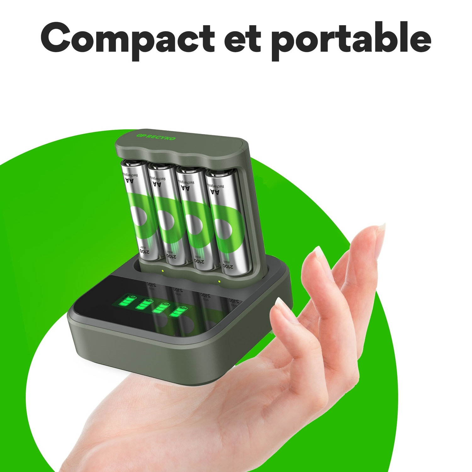 Main tenant un chargeur de batterie avec quatre piles AA, design vert et noir.