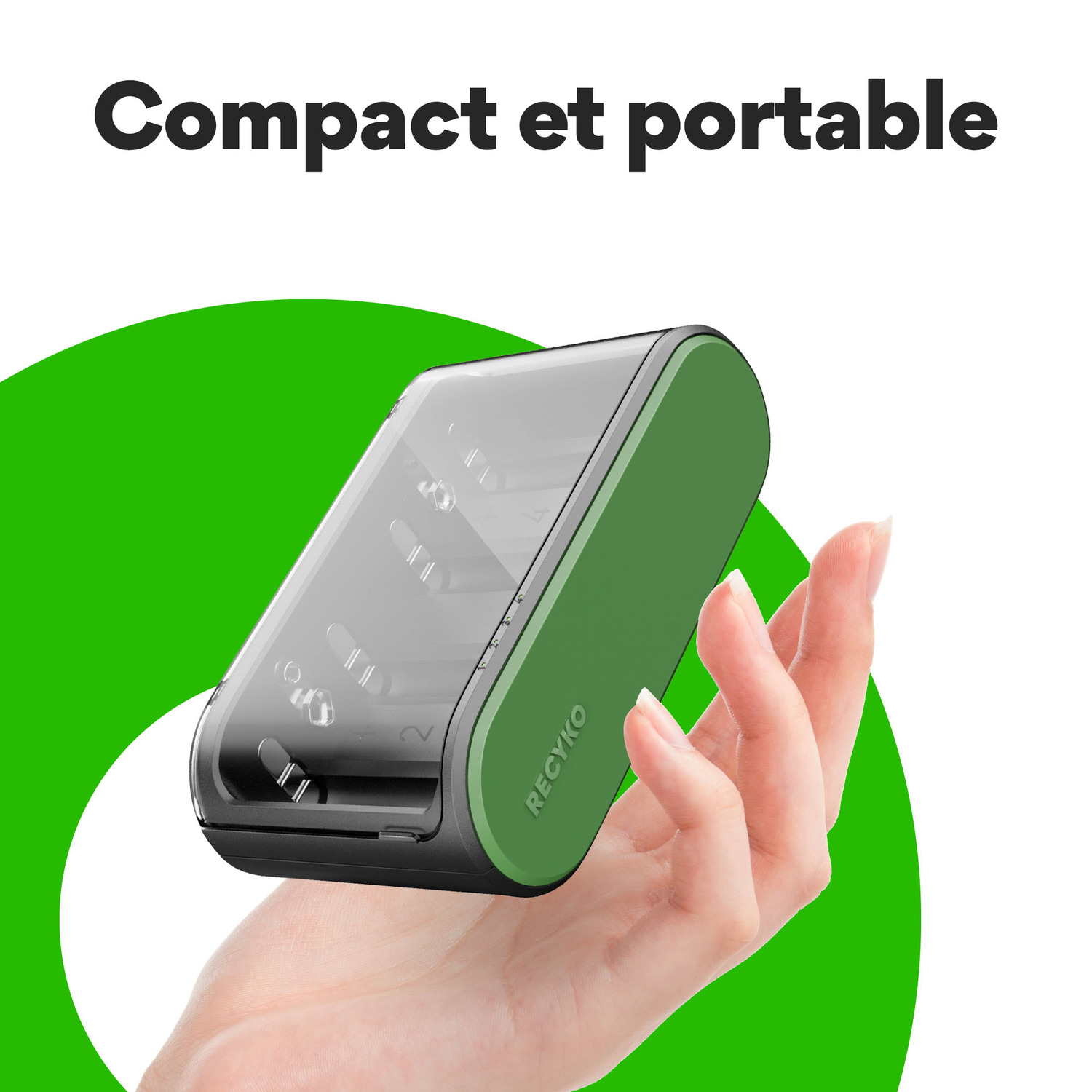 Une main tenant un petit appareil vert et noir devant un fond vert.