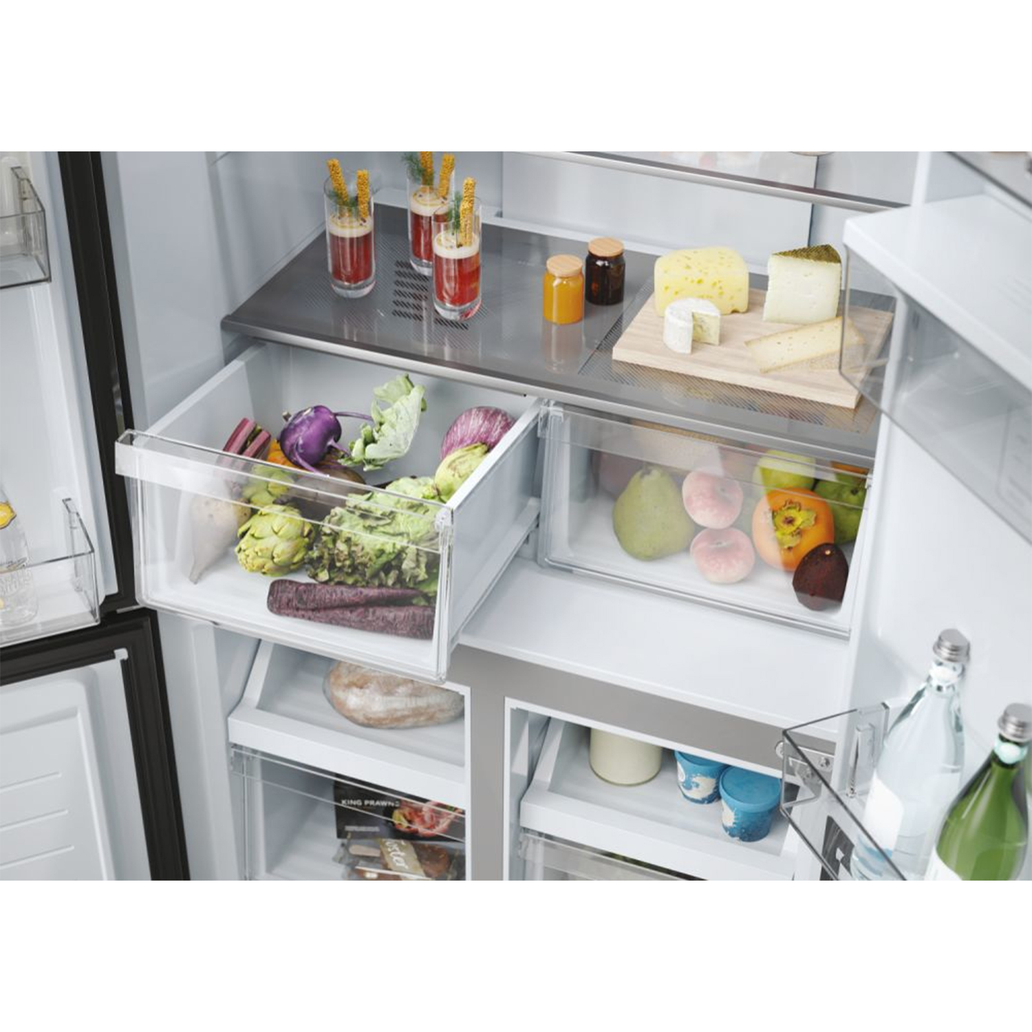 Interno del frigorifero con cassetti. Si vedono verdure, frutta, formaggio e bevande.