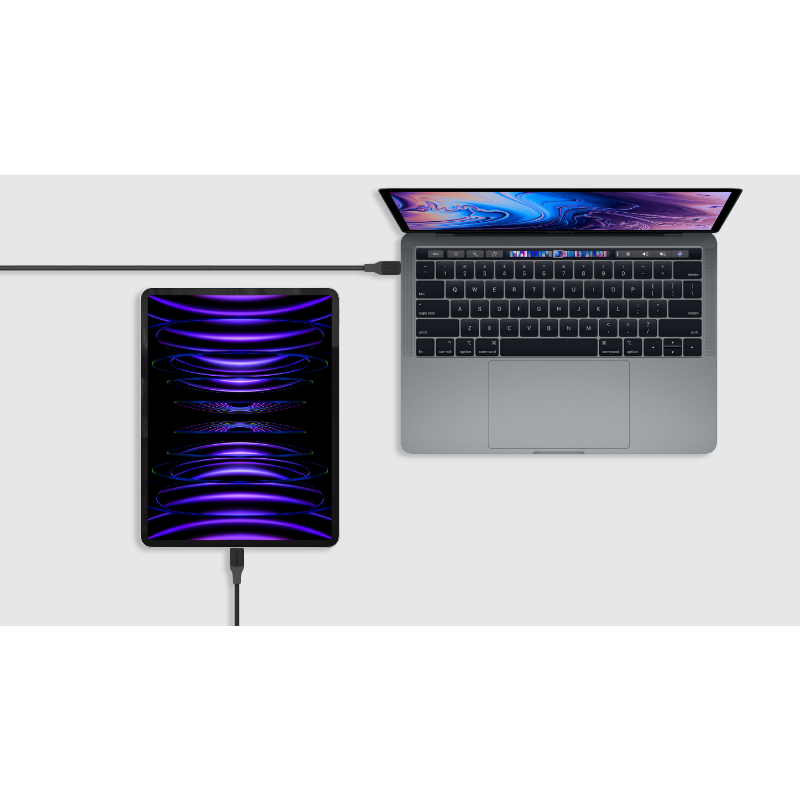 Bir iPad, şarj kablosuyla bir dizüstü bilgisayara bağlı, üstten görünüm.