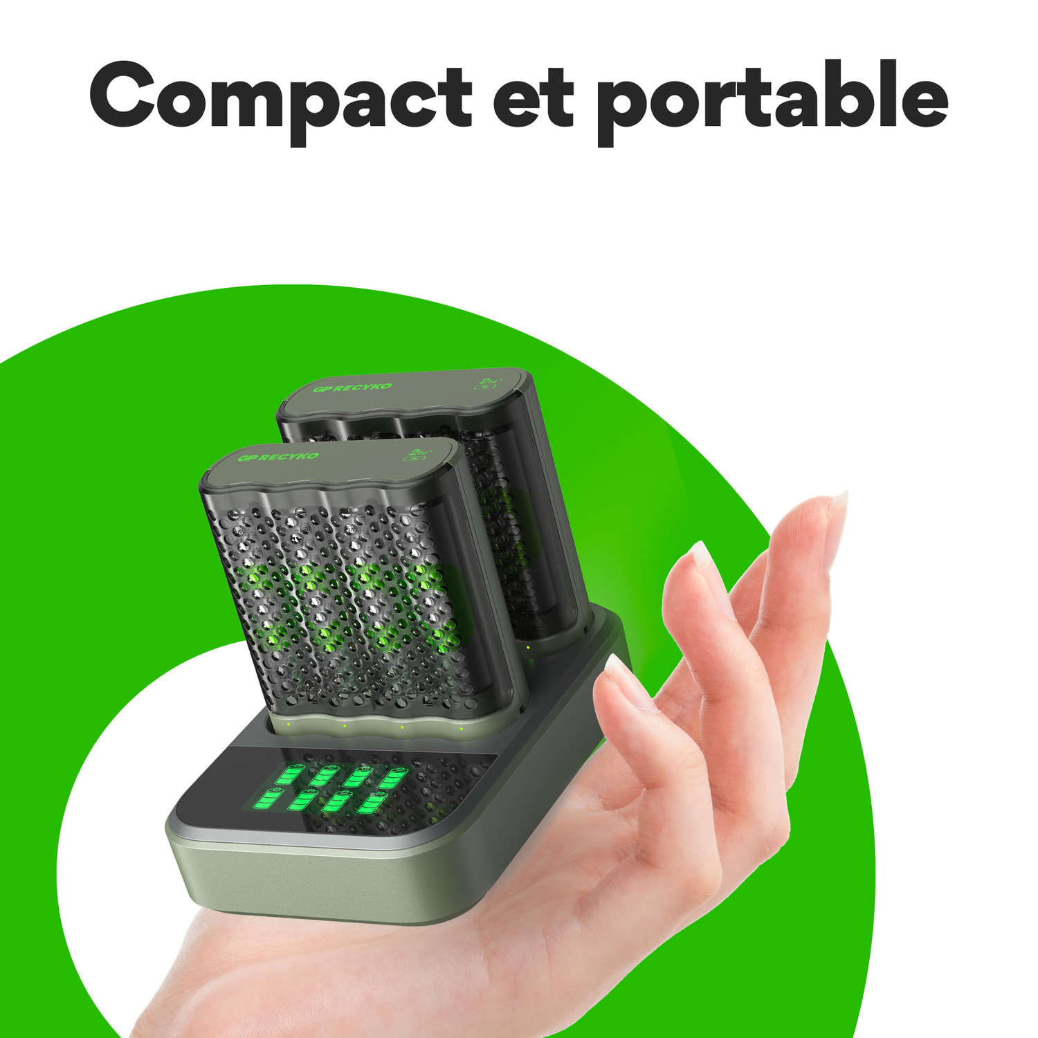 Main tenant une station de charge avec deux batteries noires et vertes, avec des lumières vertes allumées.