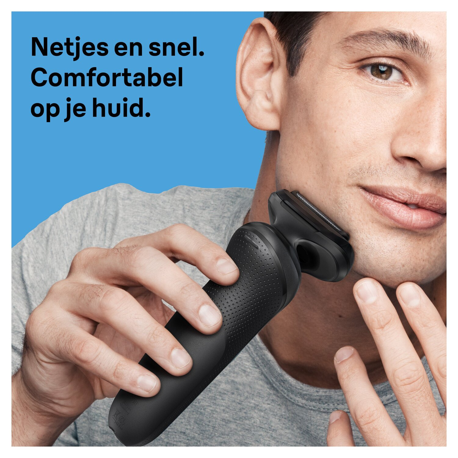 Een man scheert zijn gezicht met een zwart elektrisch scheerapparaat. De achtergrond is blauw.