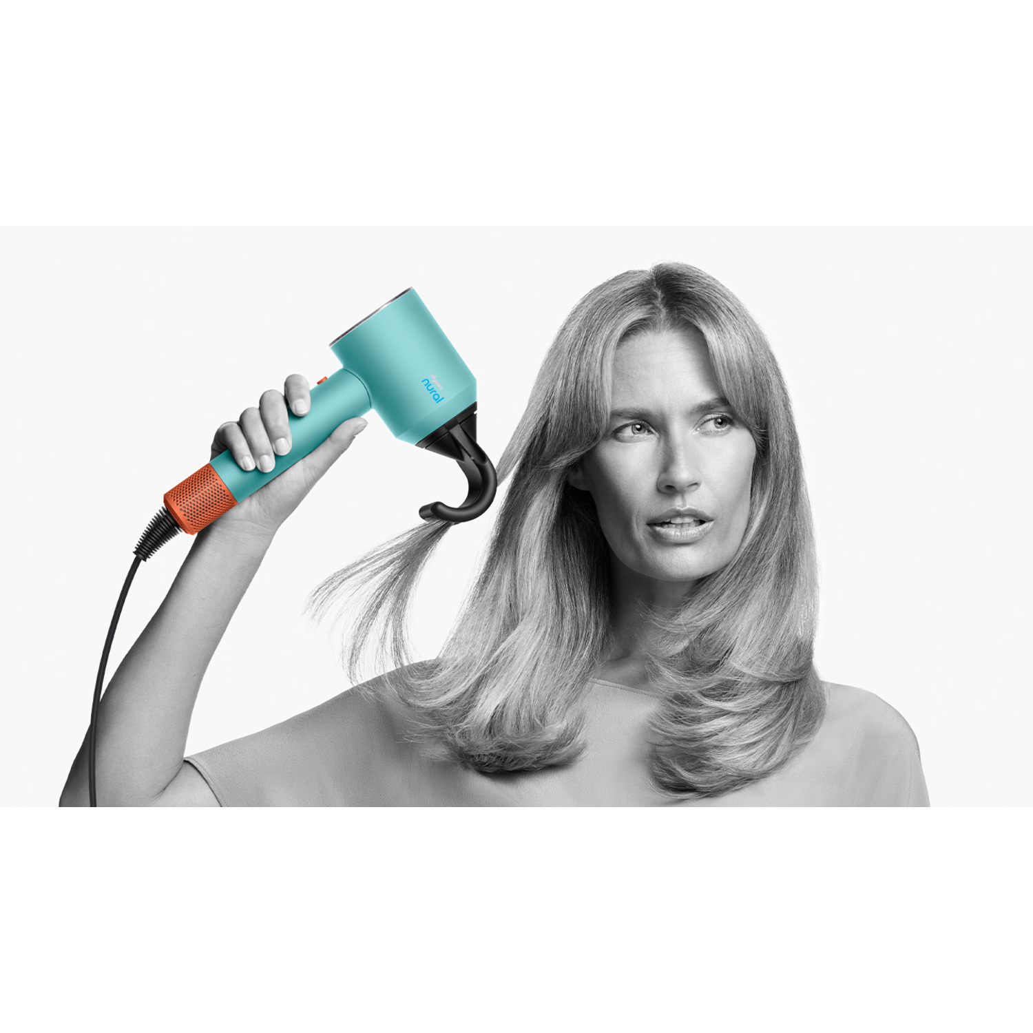 Vrouw gebruikt een turquoise föhn met oranje accenten. Zwart-witte achtergrond.