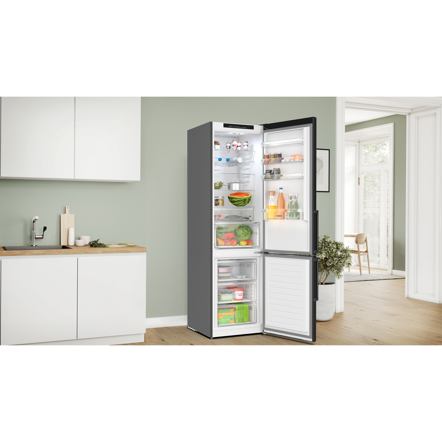 Open refrigerator with food inside. Grey exterior, bright interior. Kitchen setting with white cabinets and green wall.