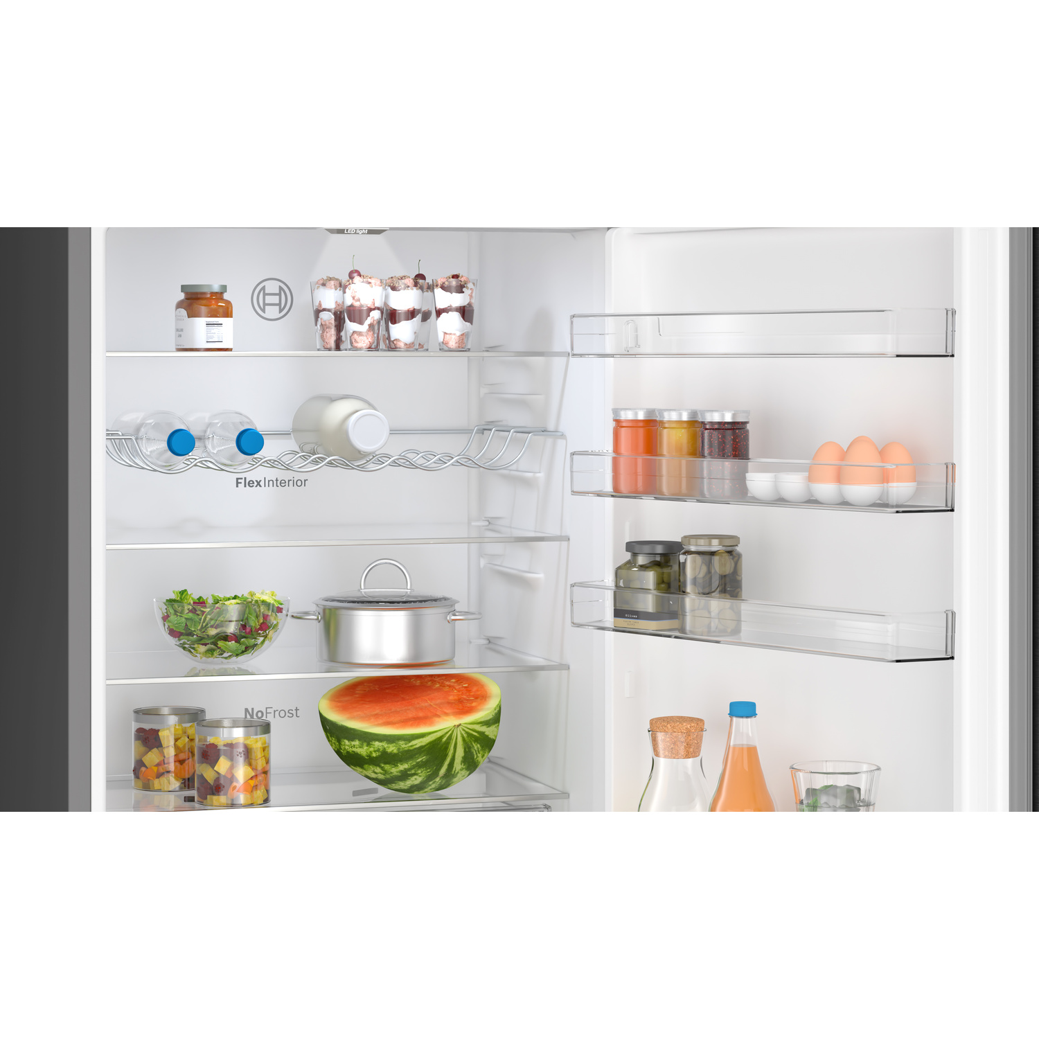 Refrigerator interior. Shelves with various food items: jars, bottles, salad, watermelon and eggs.