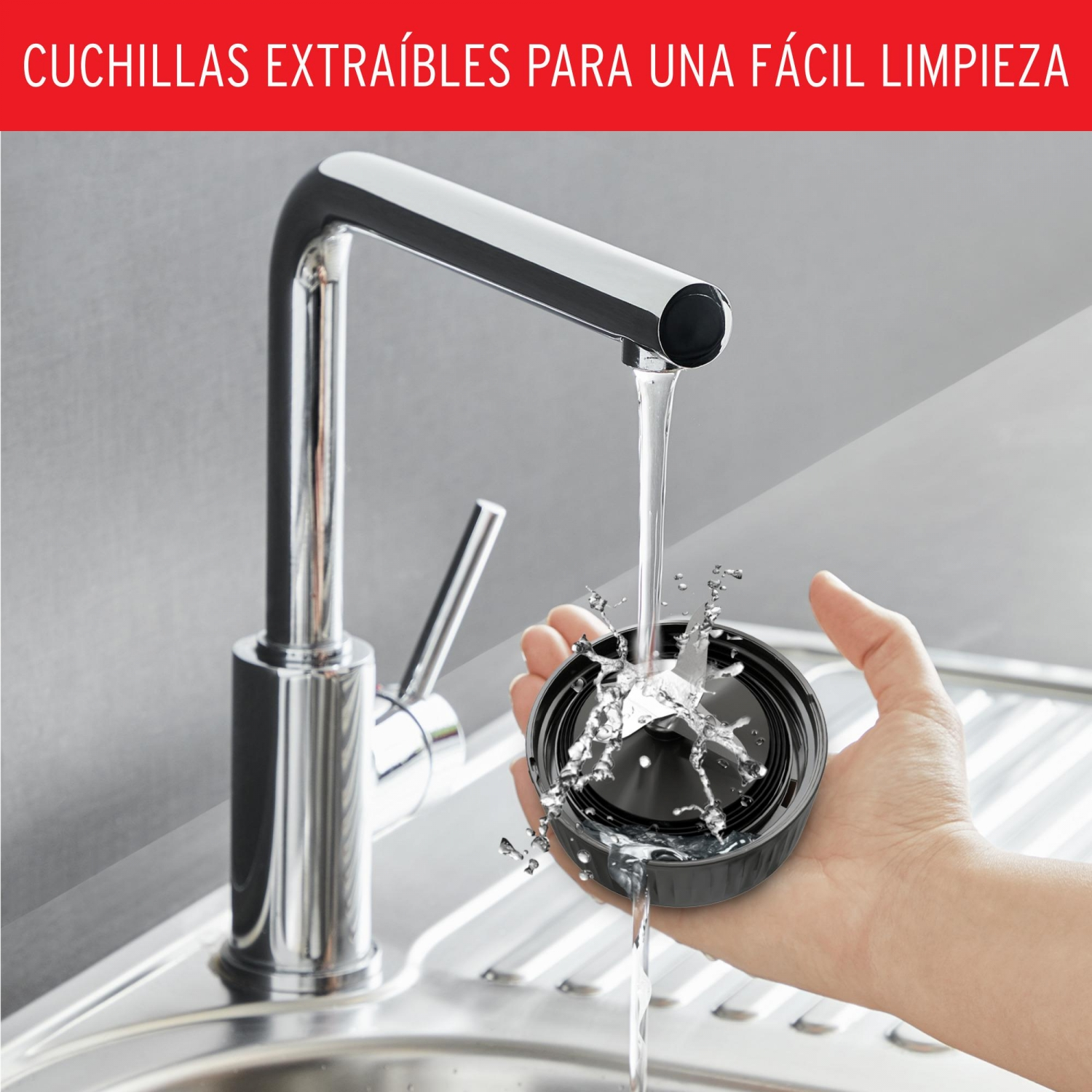Una mano que sostiene un componente de licuadora bajo agua corriente. El agua salpica.