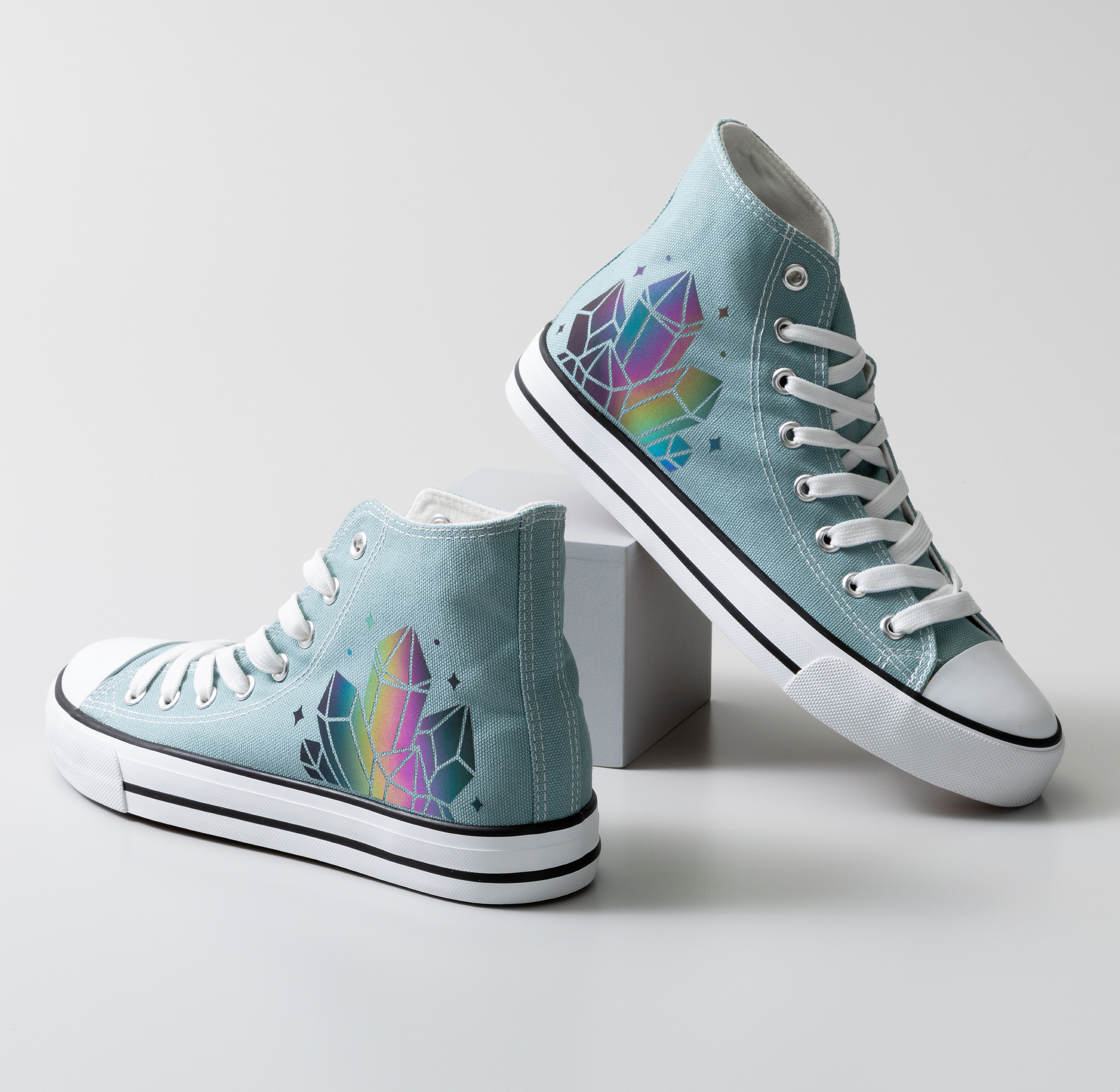 Zwei hellblaue High-Top-Sneaker mit Kristall-Design stehen auf weißer Oberfläche.
