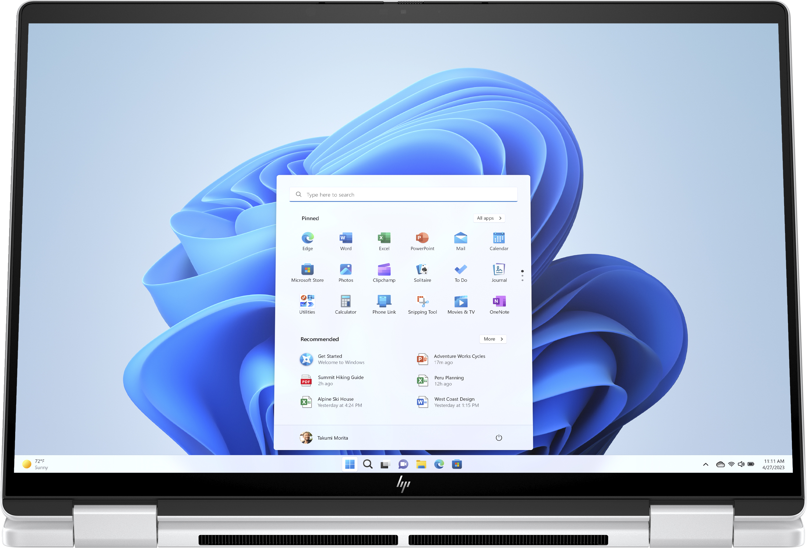 Ein Laptop-Bildschirm zeigt den Windows 11 Desktop mit verschiedenen App-Symbolen und einer Suchleiste.
