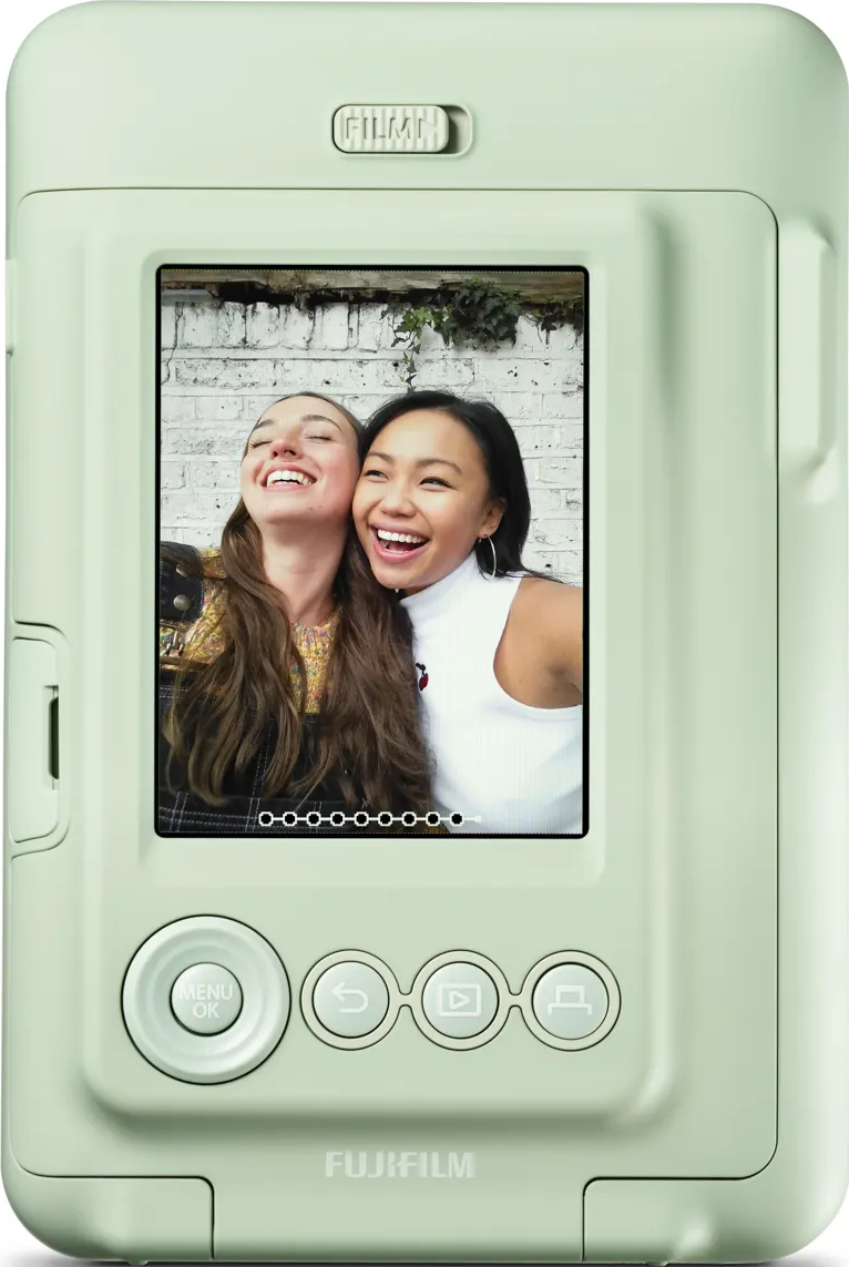 Appareil photo Instax vert avec une photo sur écran montrant deux femmes souriantes.
