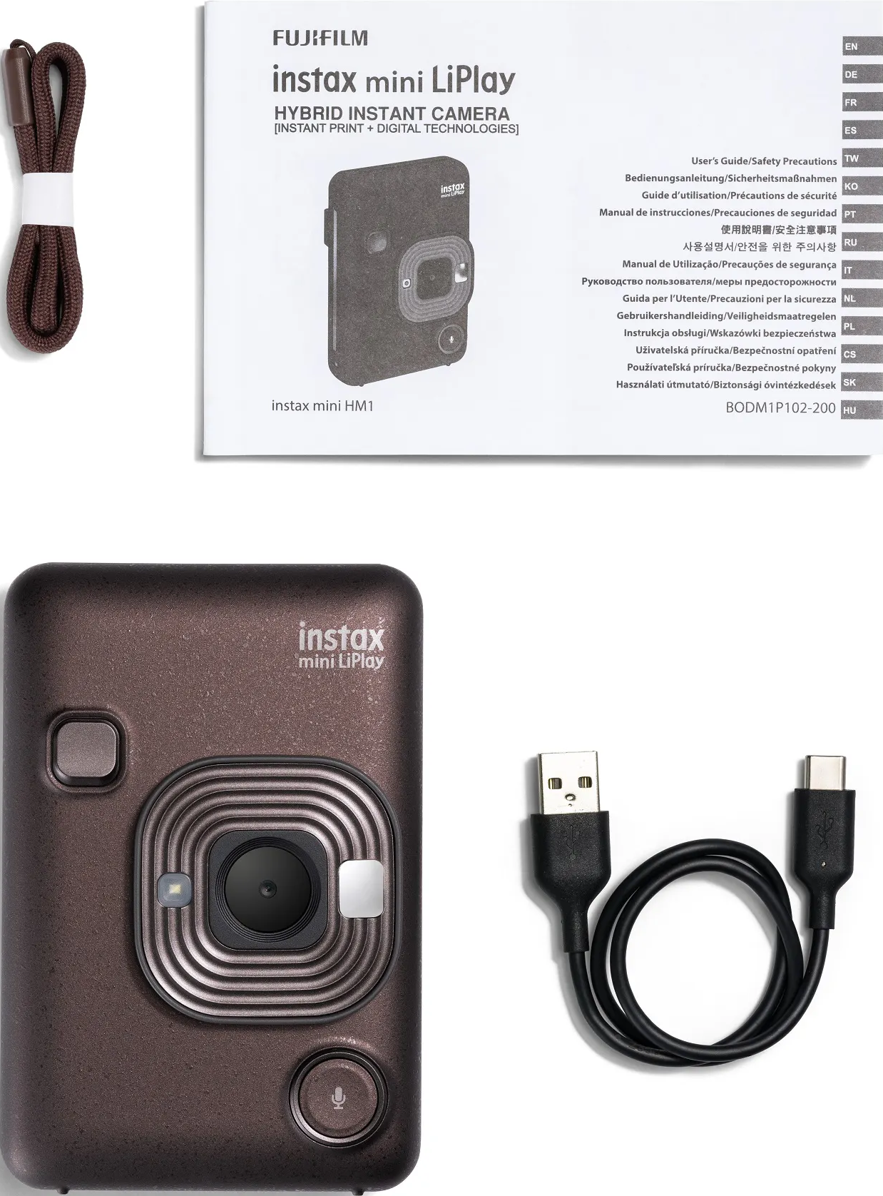 Appareil photo Instax mini LiPlay avec accessoires : sangle et câble USB, sur une surface blanche.