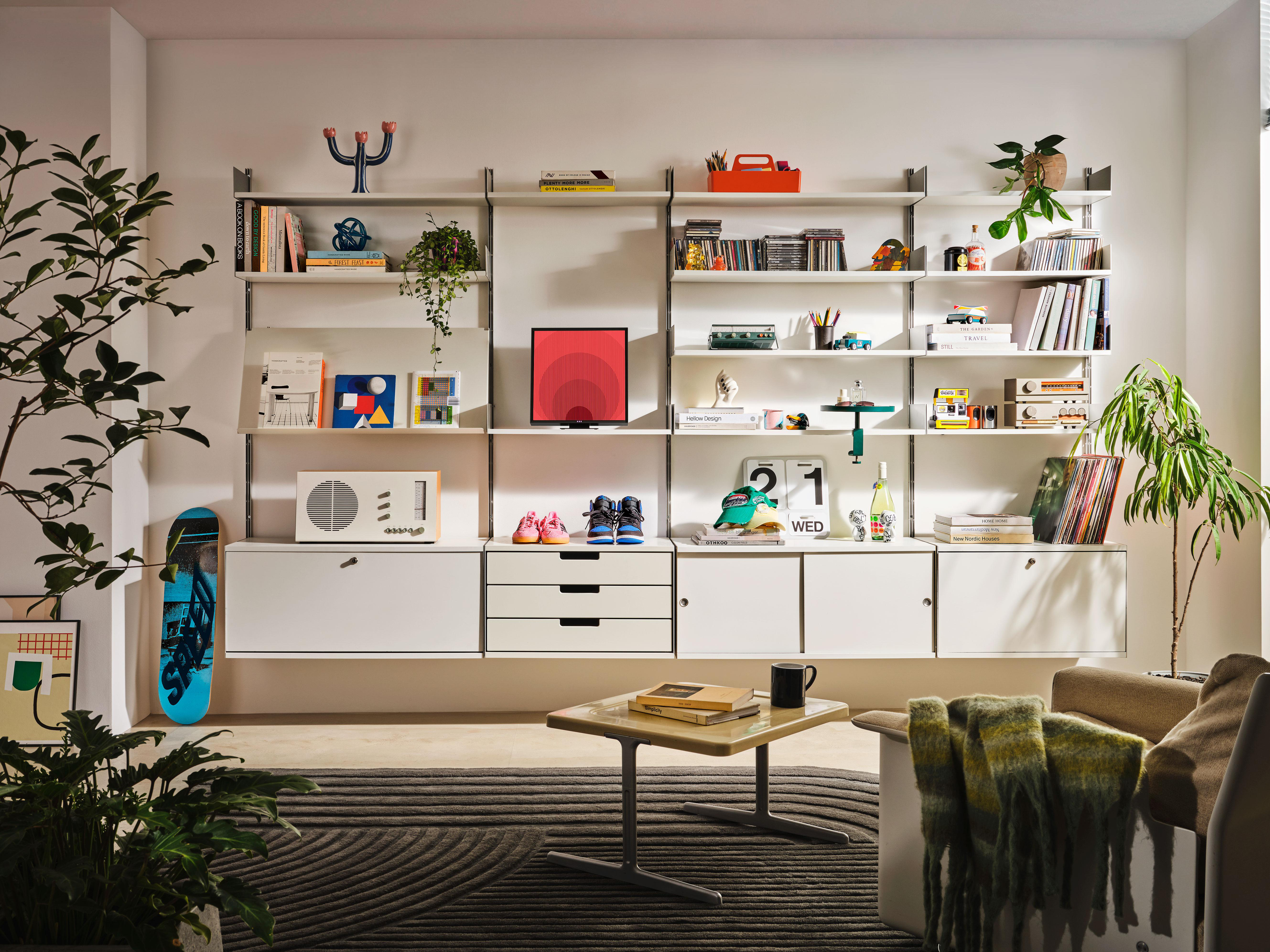 Modernes Wohnzimmer mit Regalen, bunten Gegenständen, Skateboard.